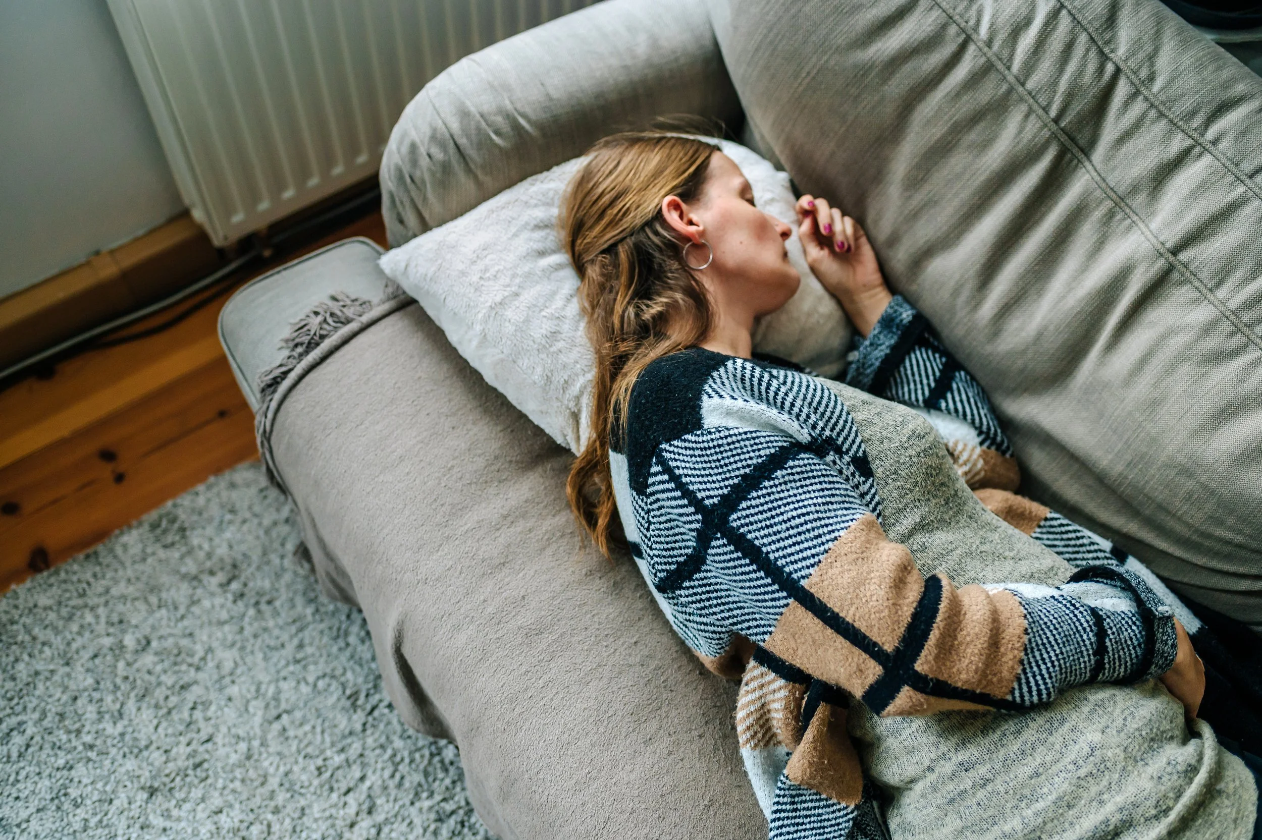 Schwangere Frau fotografiert sich selbst schlafend auf einem Sofa als Erinnerung an die Schwangerschaft.