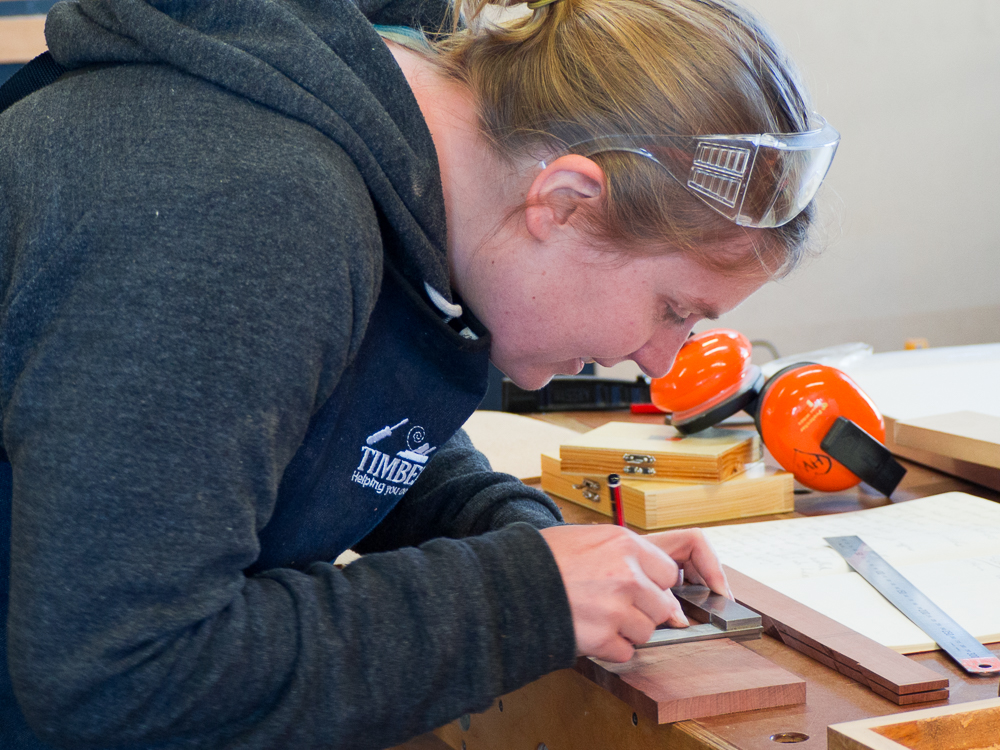 Ally marking out parts for her box project.
