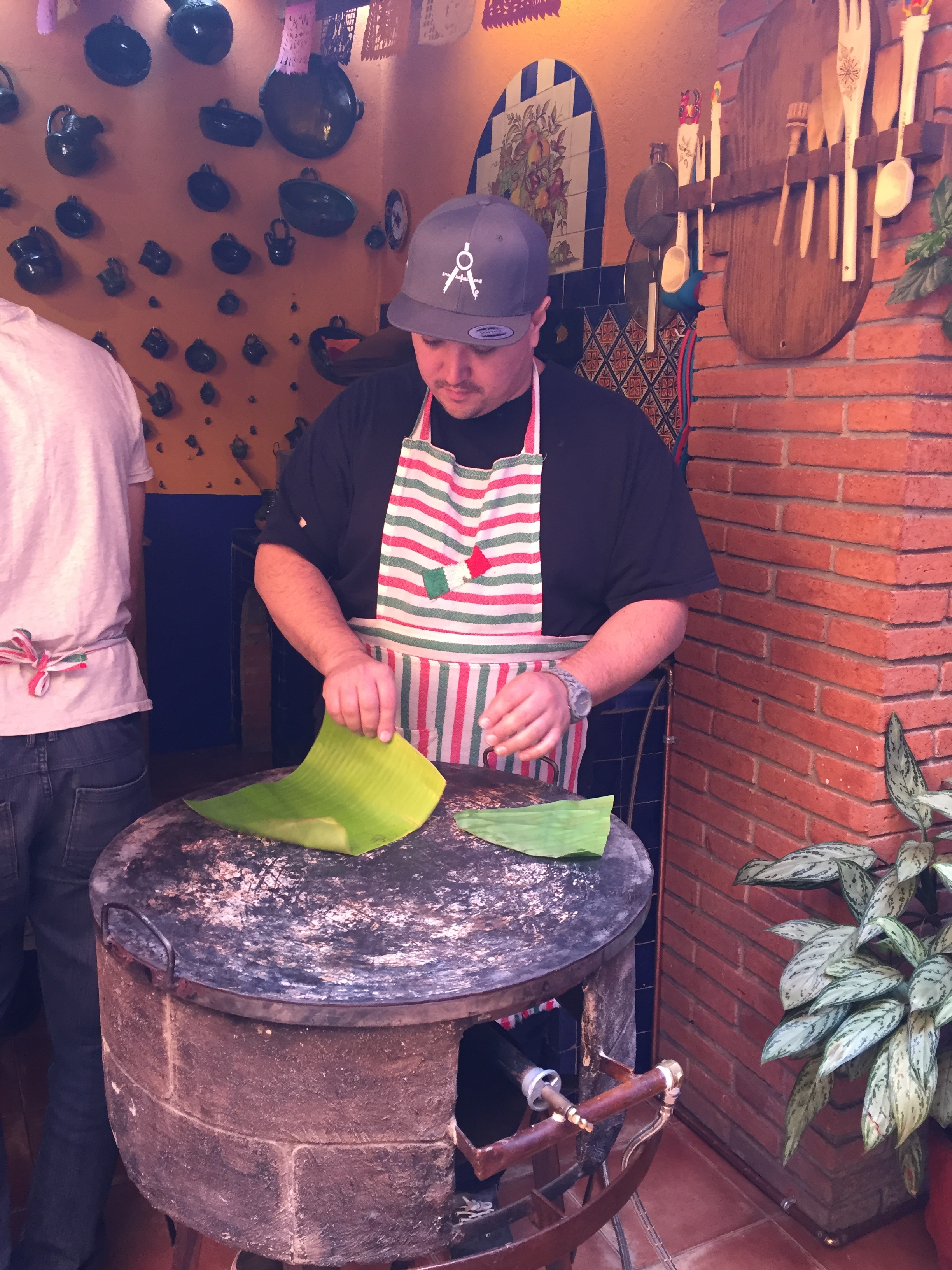 Visiting Professor/ Chef Jason Stanhope tries his hand at toasting banana leaves for wrapping tamales.