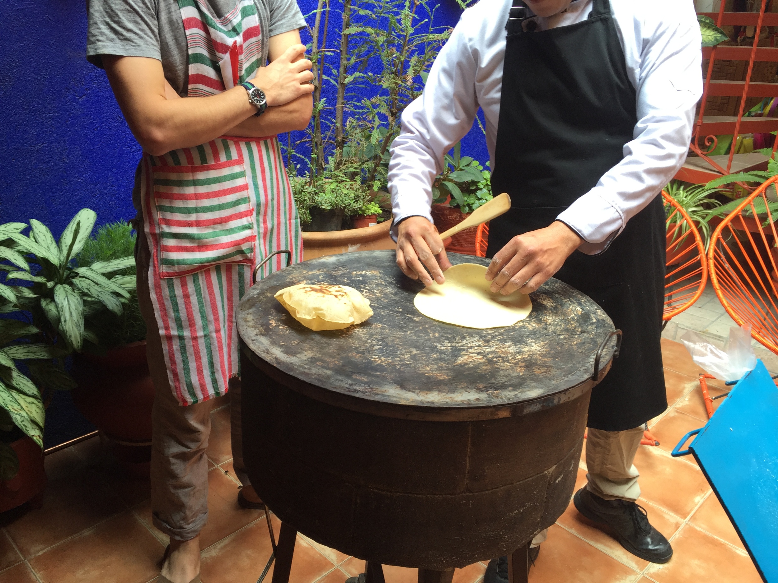 Chef Gerardo shows a fellow student from NYC how to gently slide the tortilla onto the tamal.