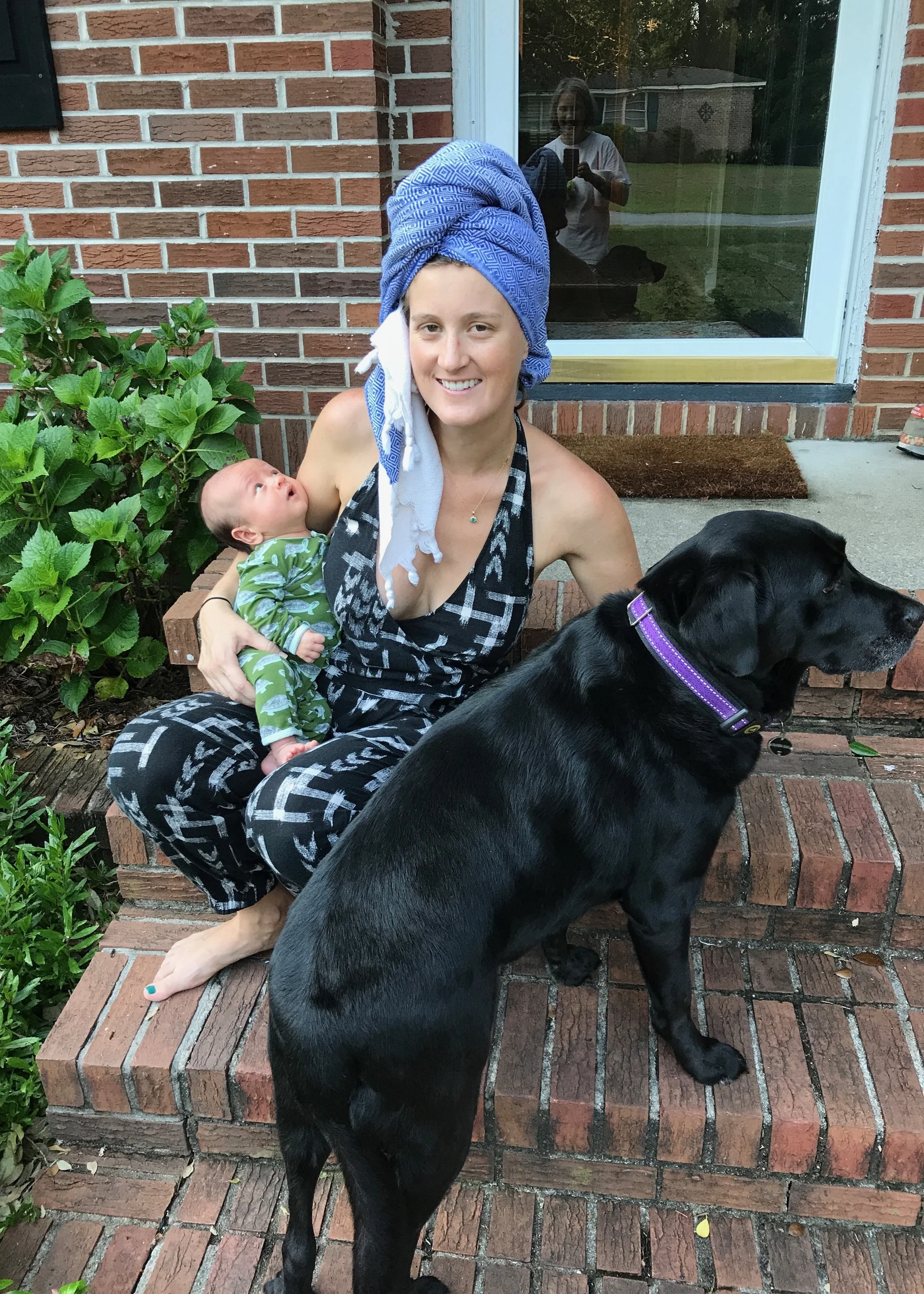In an all-natural state, wearing a jumpsuit paired with an incredibly chic towel turban, plus best accessories Baby Leo and Moses the family dog.