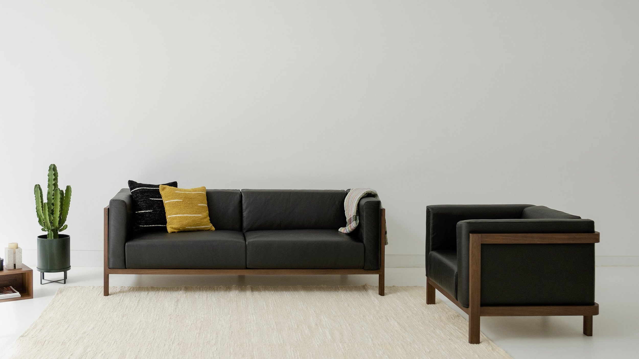 A two-seater sofa, a three-seater sofa, and a one-seater chair are each available in ash, oak, and walnut woods. Choose from Natural, Almond, Brown, Coffee, Olive, and Black leathers, and a variety of fabric options