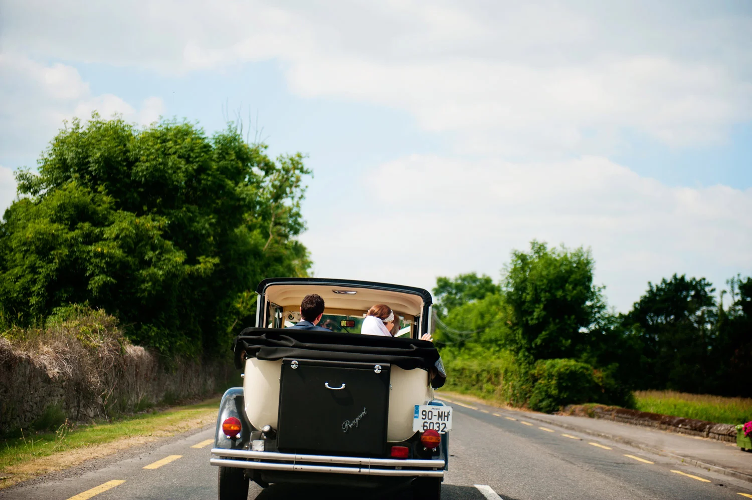 bride and groom in convertible en route to kilshane house wedding photographers tipperary ireland