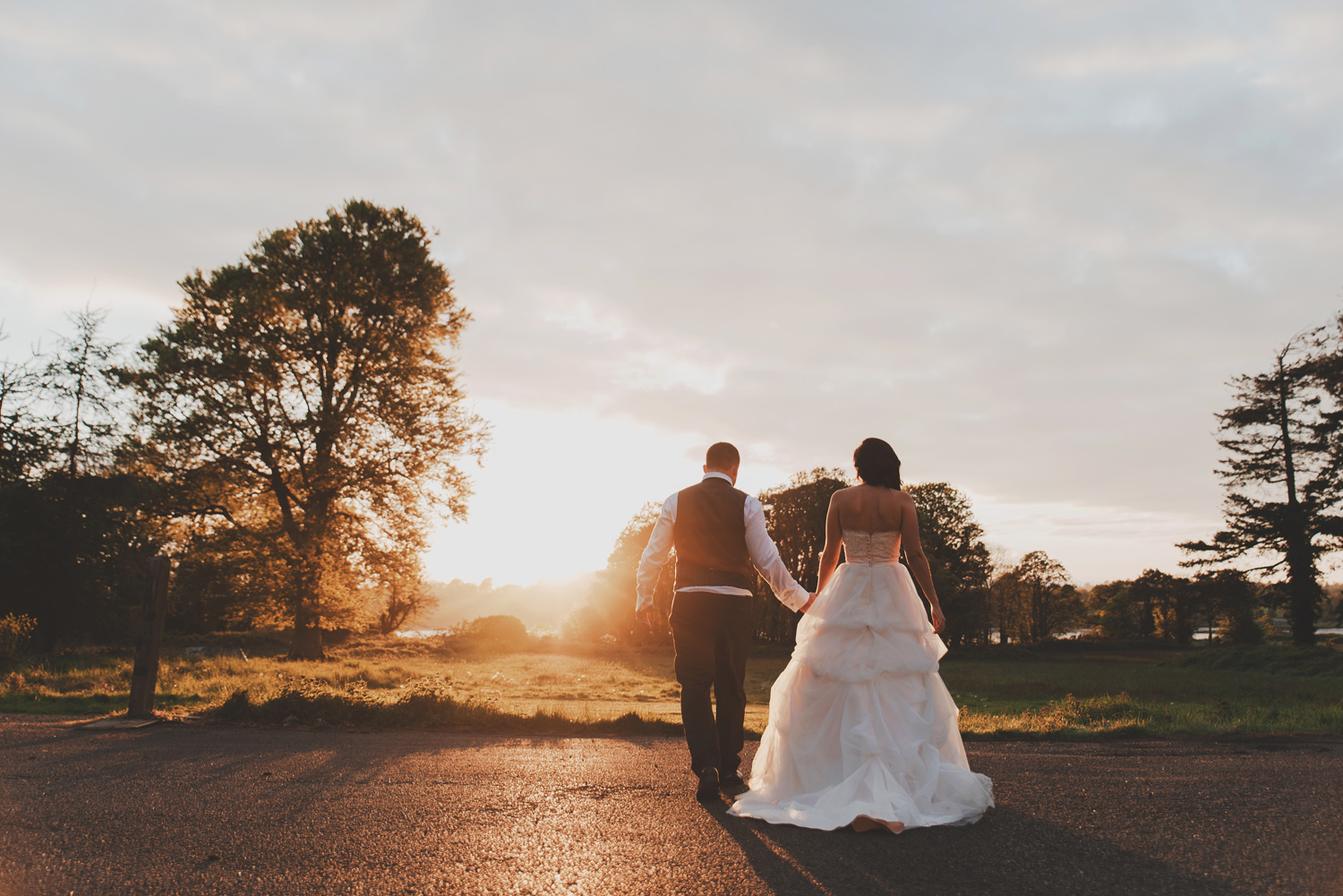 Bride & Groom walking into sunset in Waterford Castle Ireland. Wedding photography.