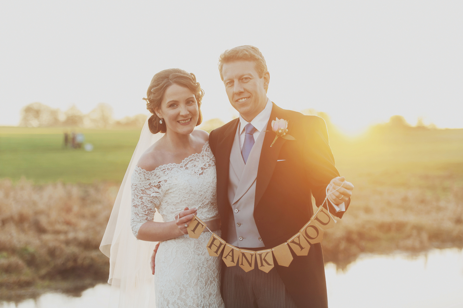 Bride and groom at sunset in Carton House with thank you banner. Wedding photographers Ireland.