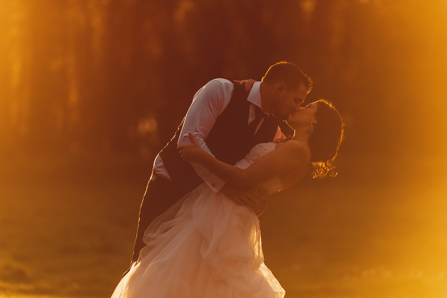 groom dips bride by sunset waterford castle ireland red and orange light wedding photography ireland