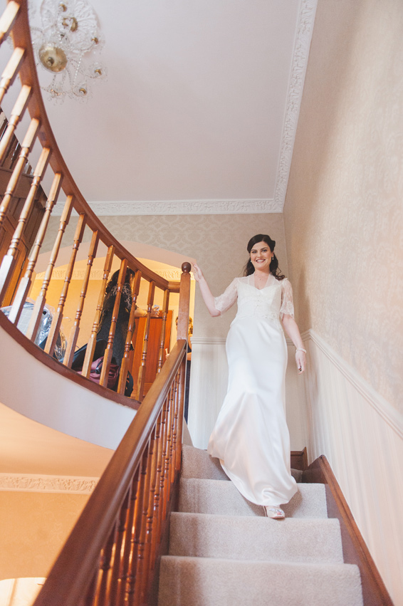 Bride walking down the stairs on the morning of the wedding