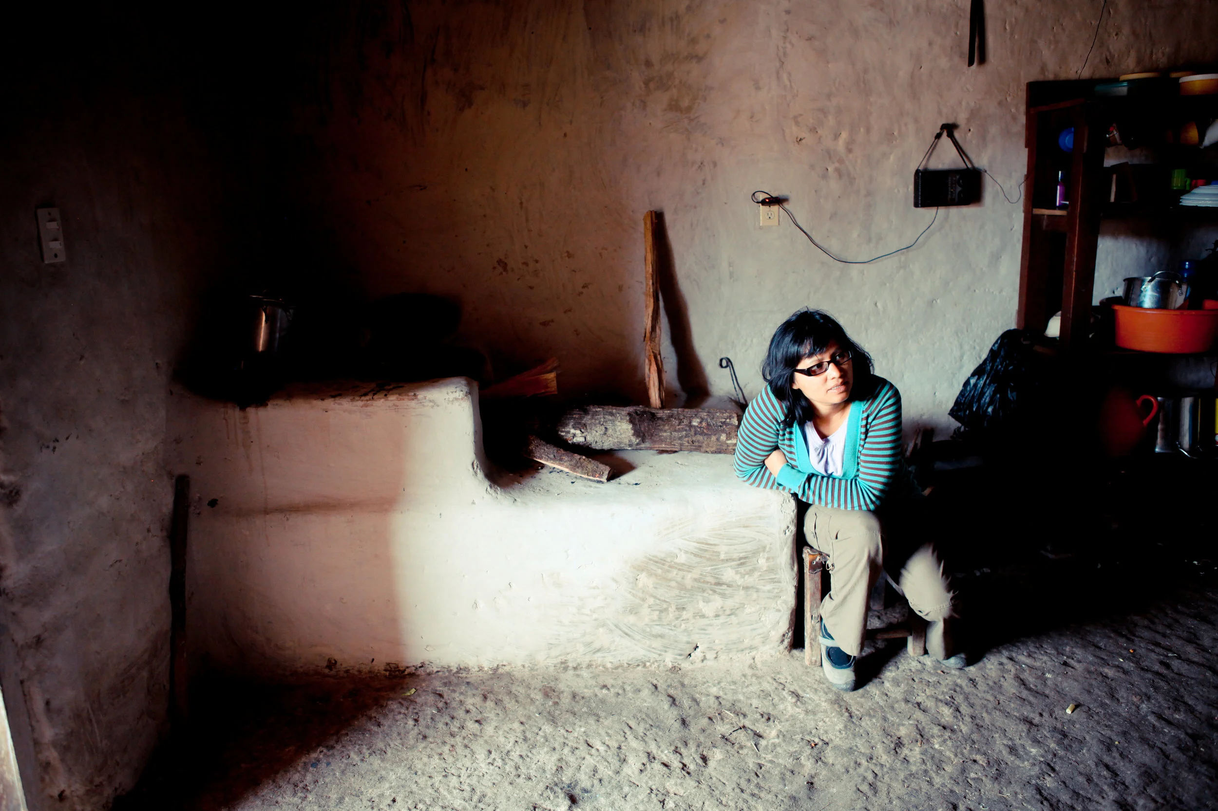 Mayra visiting with a farmer in their kitchen. Santa Elena, Honduras.