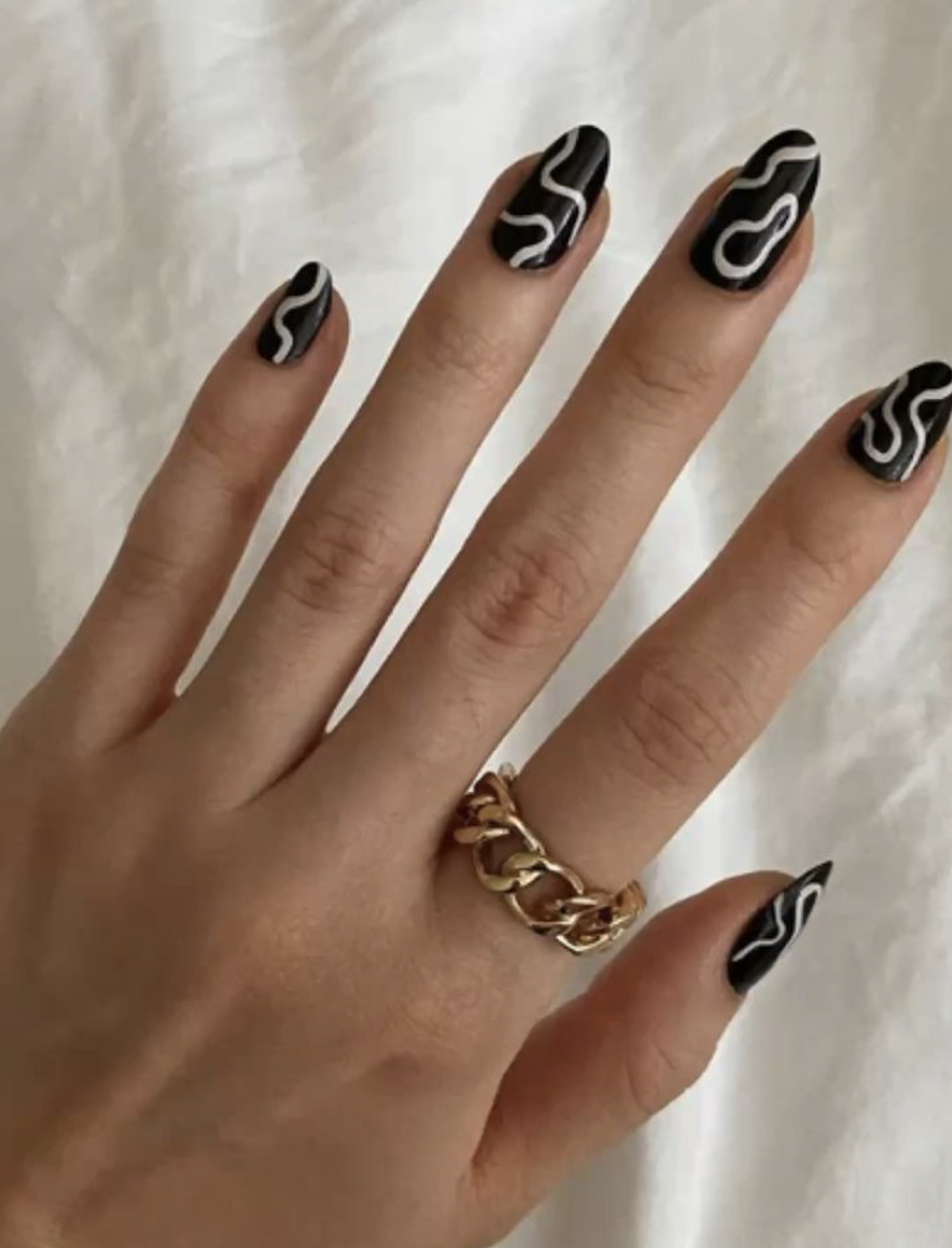 Black manicure with flowing white swirl nail art