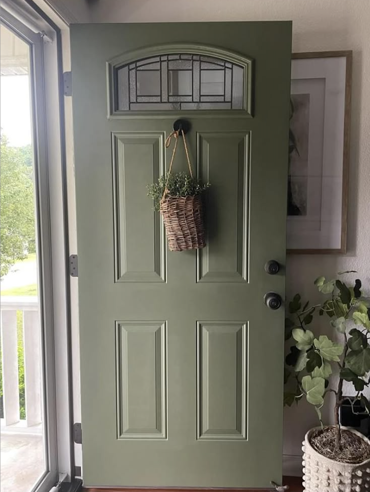 Jade green front door accented with traditional brass hardware.