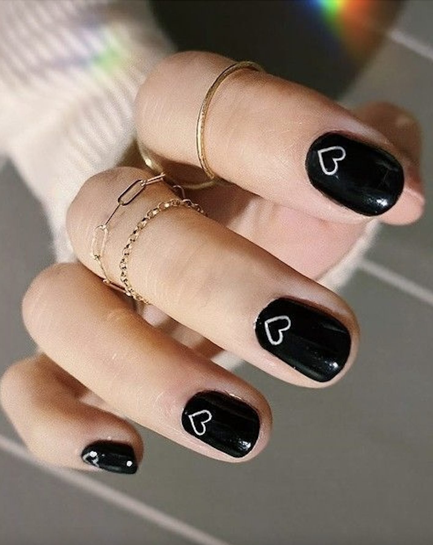 Short black nails with tiny white painted hearts