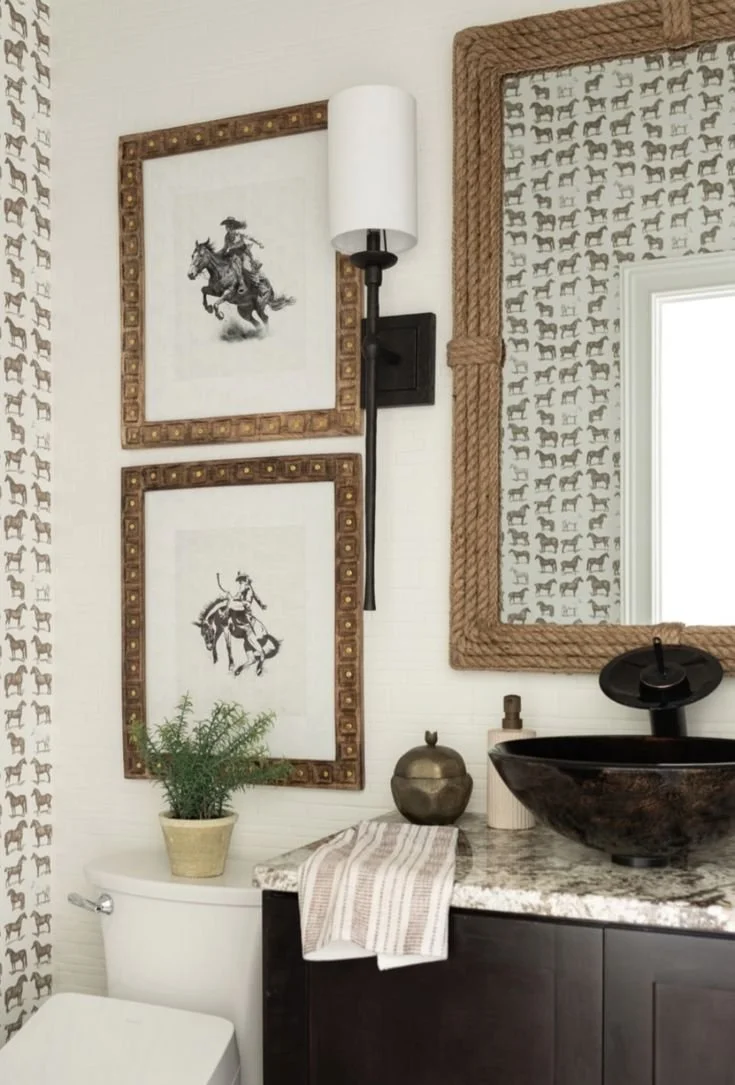 Western powder room with horse print wallpaper, bronc rider art, rope-framed mirror, and bronze vessel sink