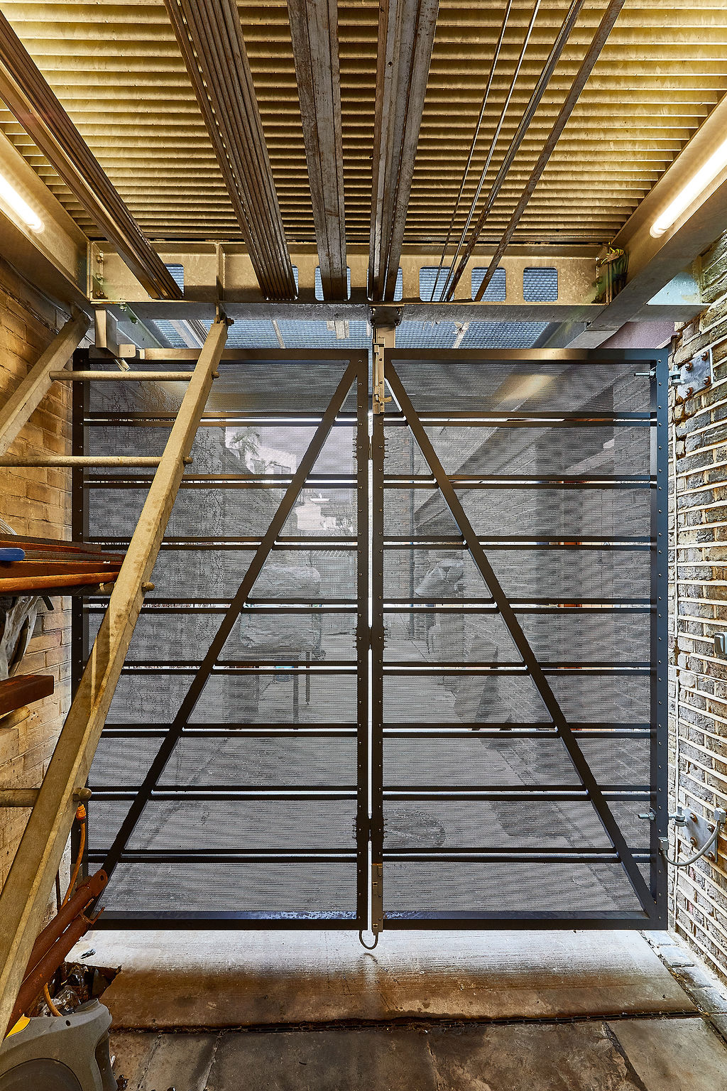 The alleyway gates under the extension were designed with perforated aluminium sheets to maintain the visual permeability at both levels