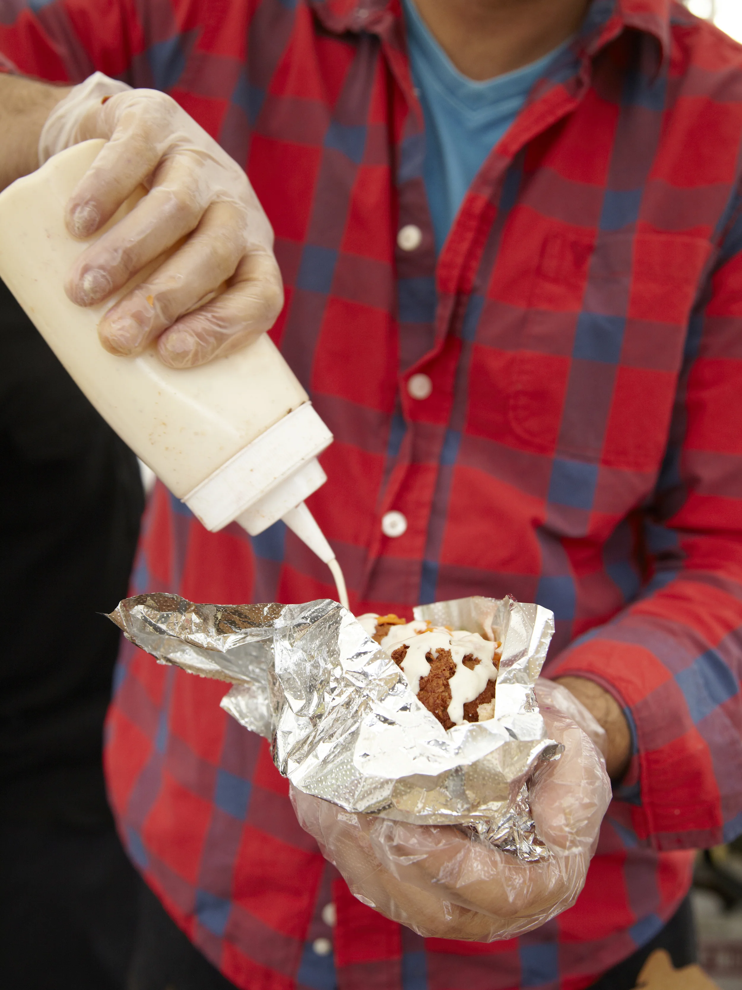 Reuben Schwartz of Vital Eats puts vegan tzatziki sauce on a falafel sandwhich at the Spa City farmers market in Saratoga Springs, NY.