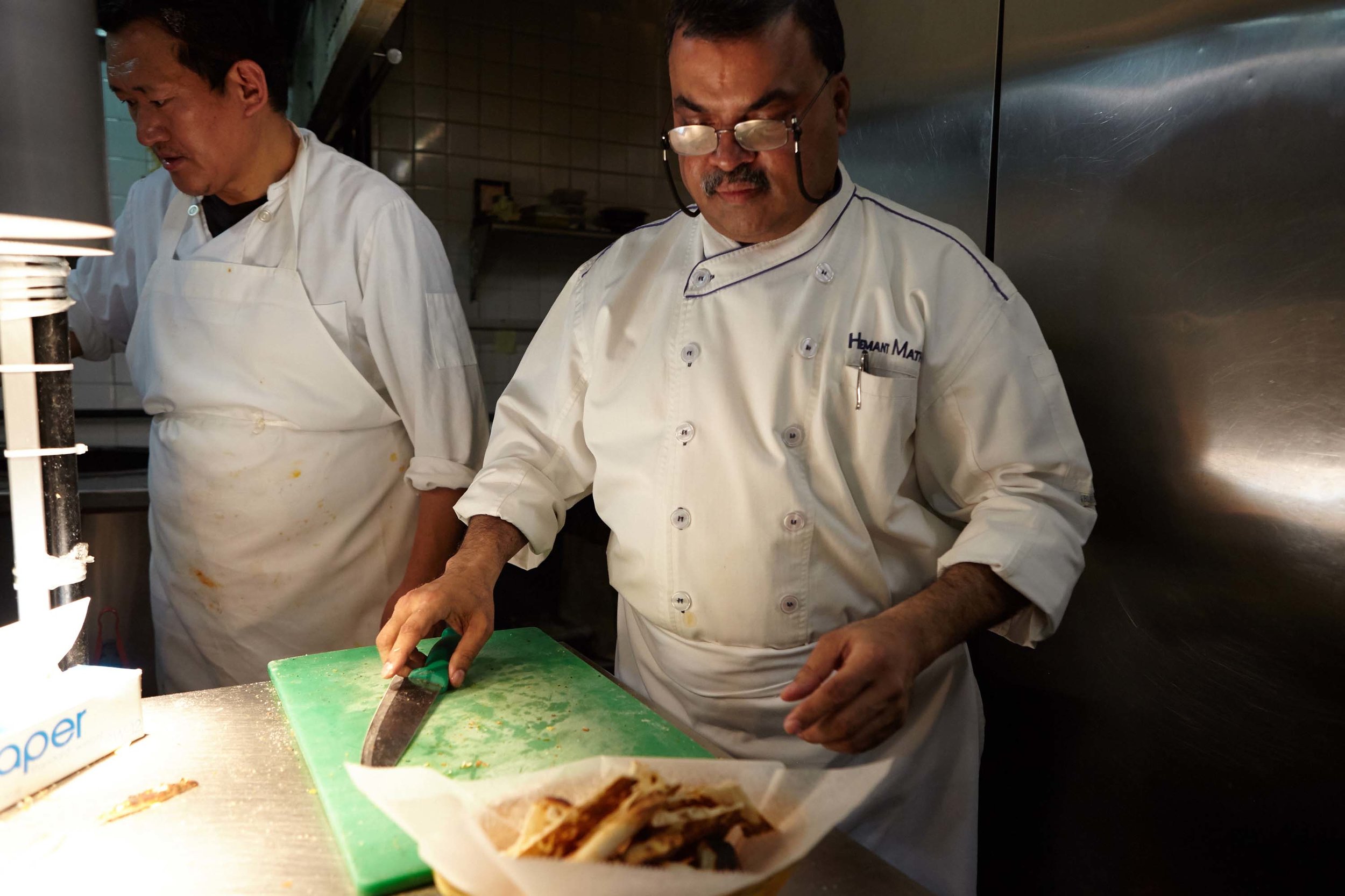 Head Chef Hemant Mathur of Sahib restaurant preparong bread in the kitchen. Chef Dimitri Nyimatsering in background.