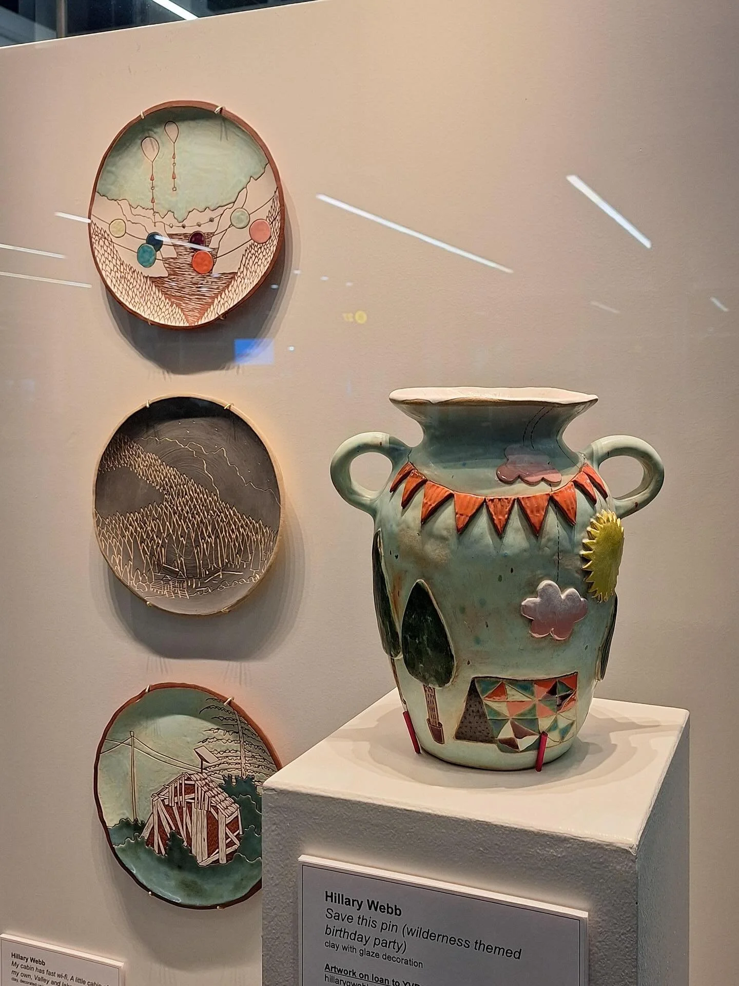 Photos of my works at YVR, domestic gate B18
Plates top to bottom:
Valley and Lake Party; A Little Cabin of My Own; My Cabin has fast Wi-fi
Vase: Save This Pin (wilderness themed birthday party) 

And a series of embroidery works on the opposite side