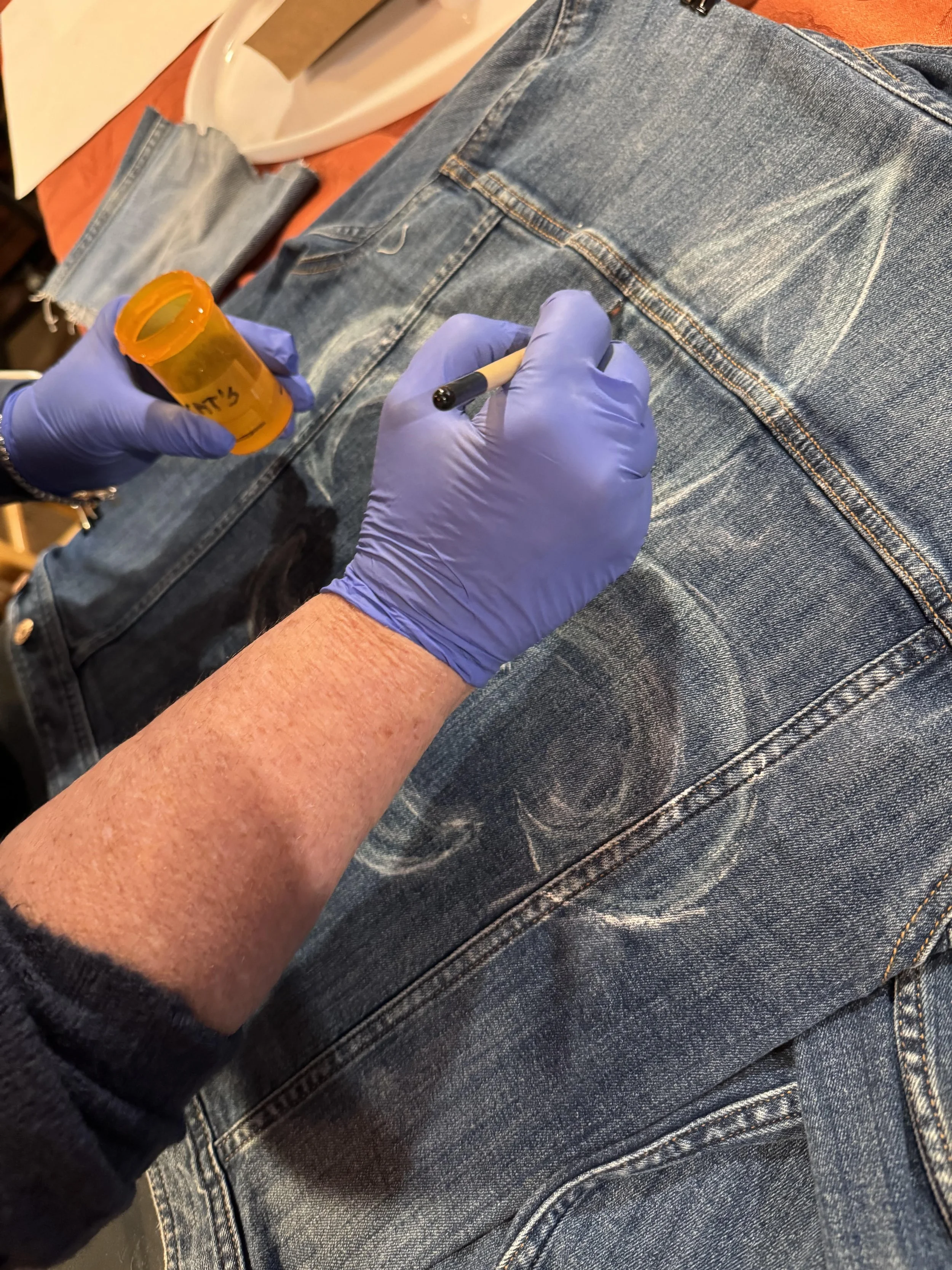 I had the special honor of teaching Jane the delicate art of bleaching paint. Here is my lovely student, confidently holding her brush in hand as she carefully lays out her unique design using bleach.