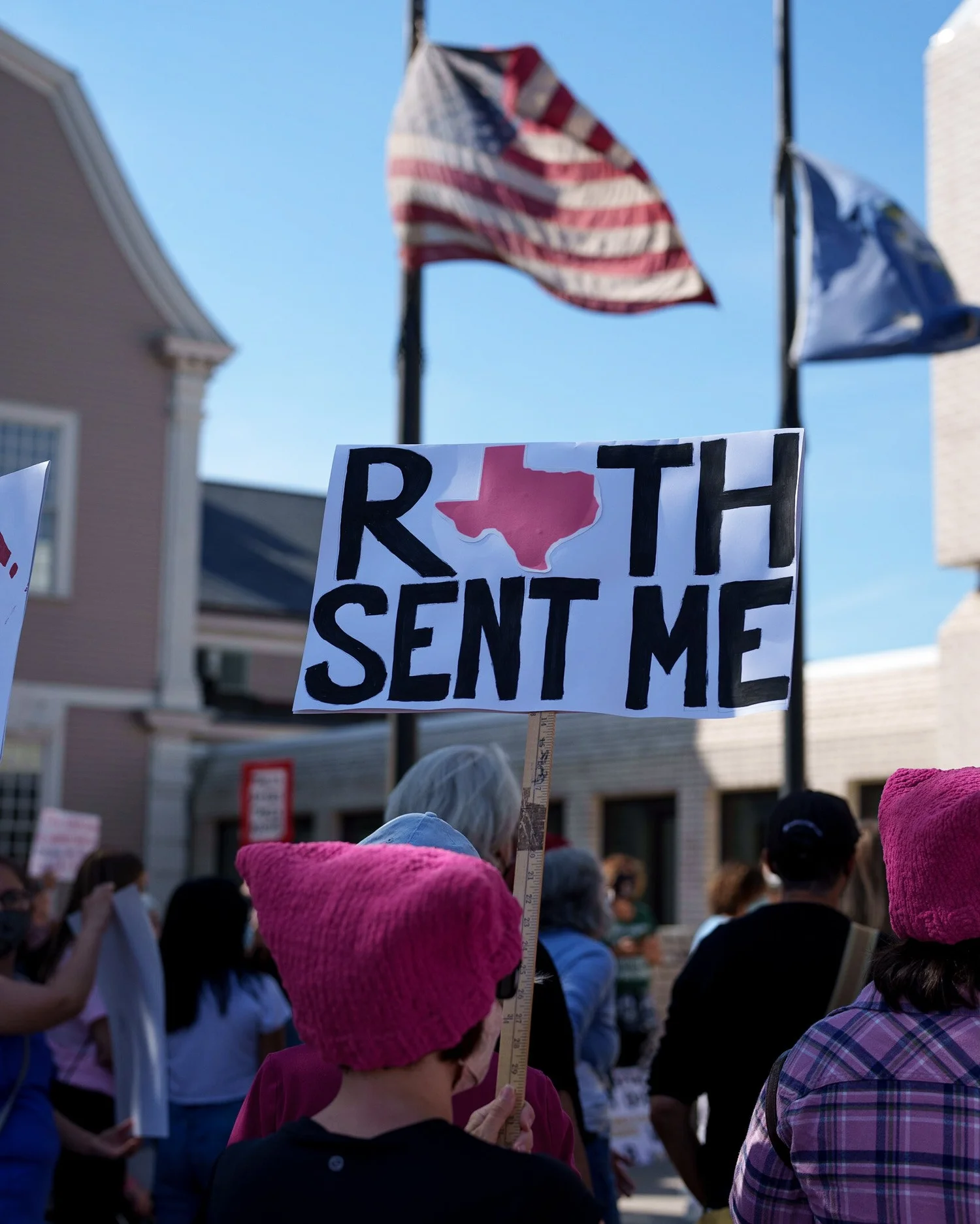 Crowd with American flags and a sign reading “RBG sent me”