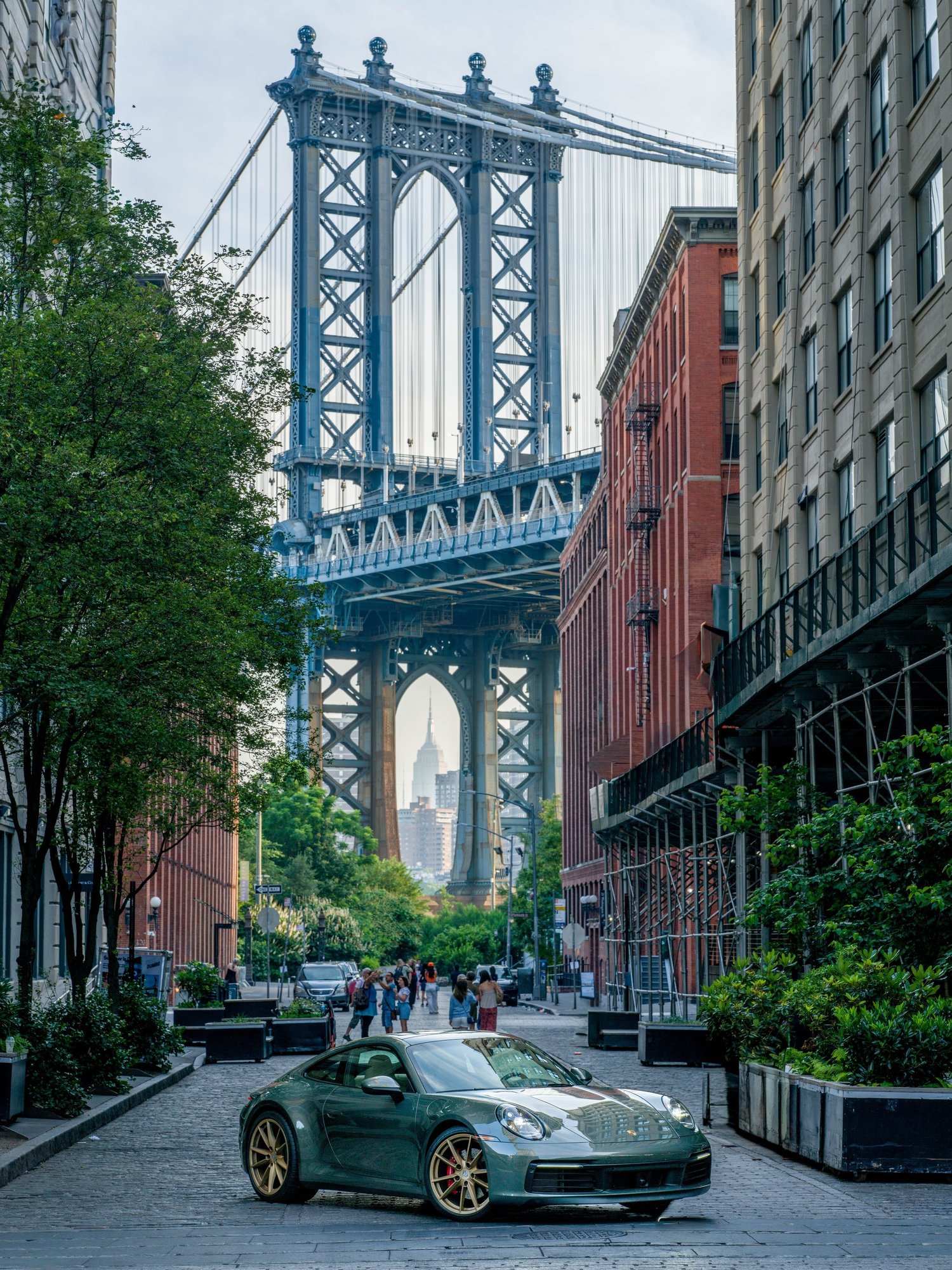 The Manhattan Bridge framed by brick buildings on a Brooklyn street