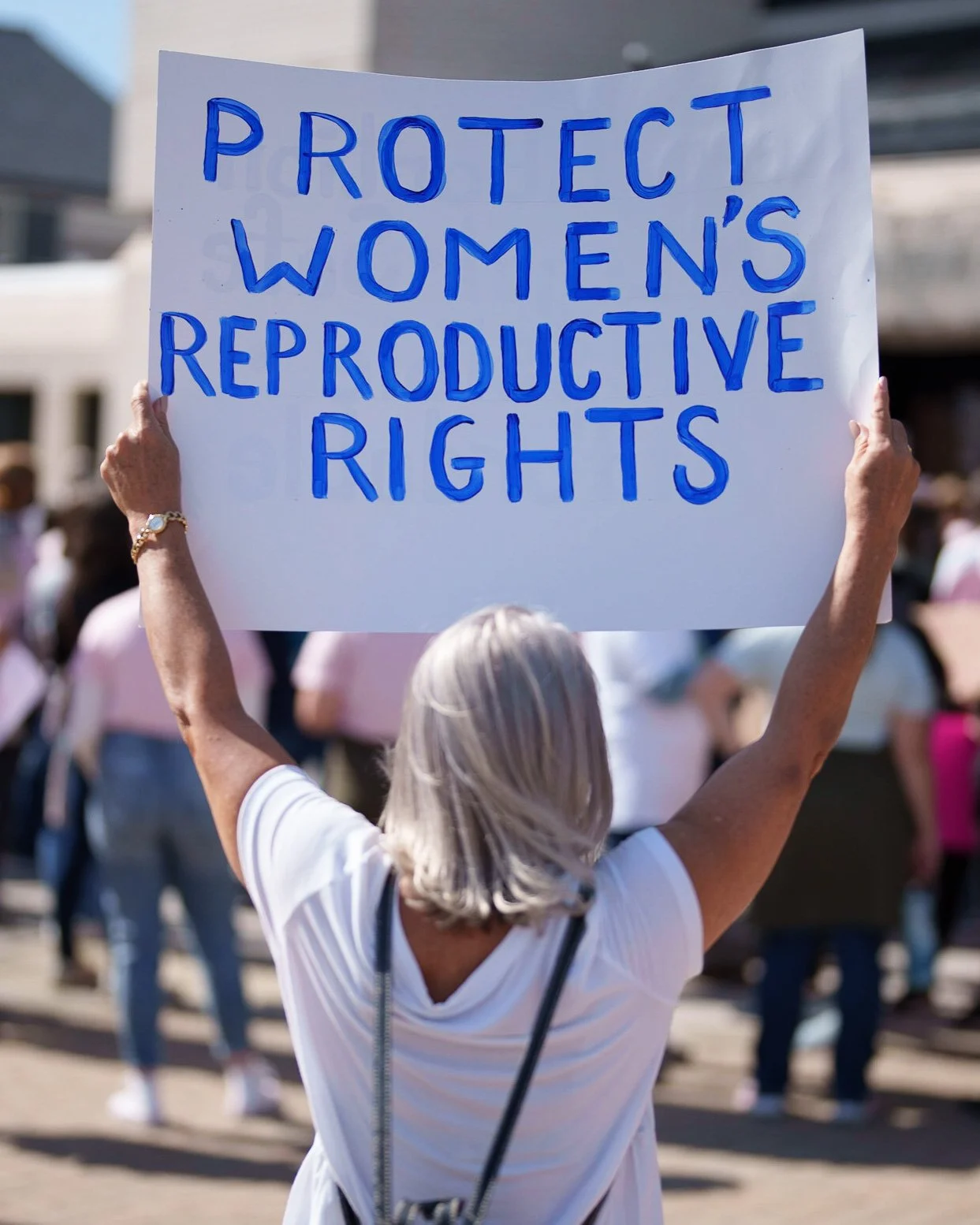 Protester holding a sign reading “Protect women’s reproductive rights”