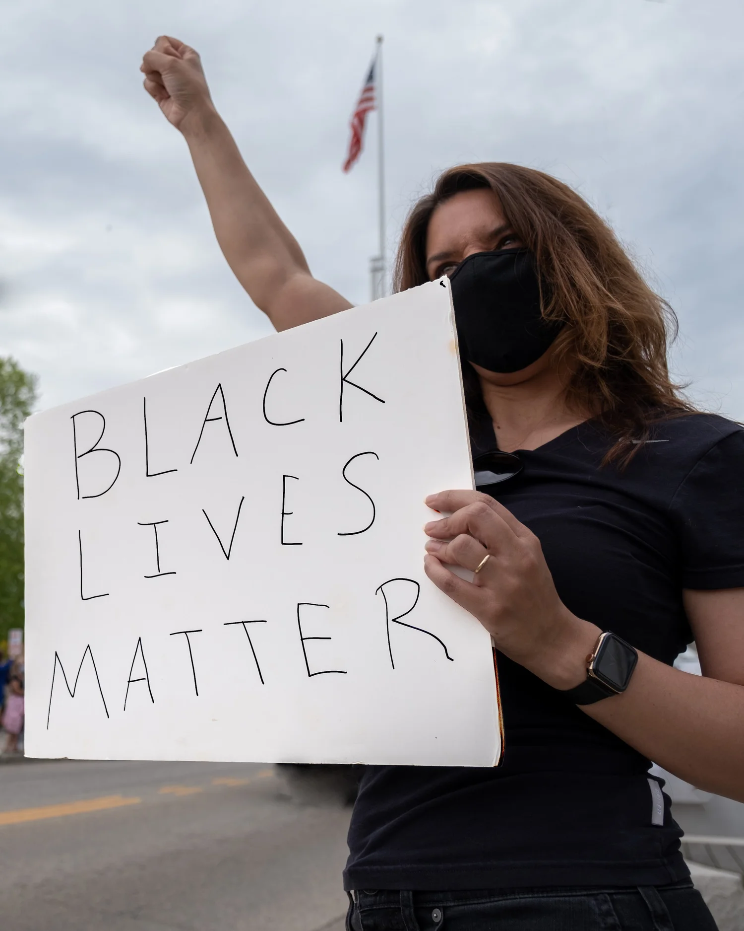 Masked woman holding a “Black Lives Matter” sign