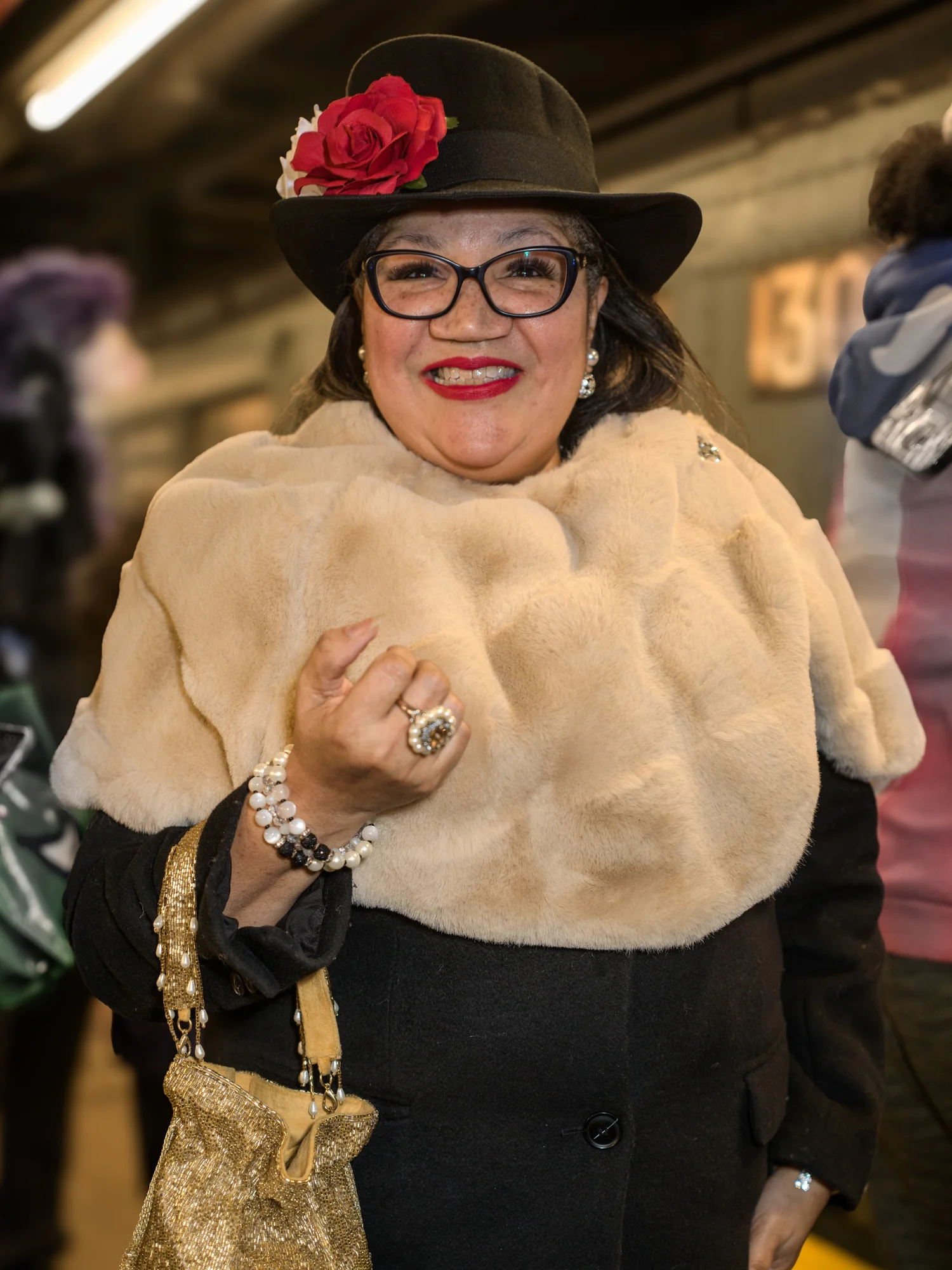 Smiling woman in a fur stole and a hat with a red rose