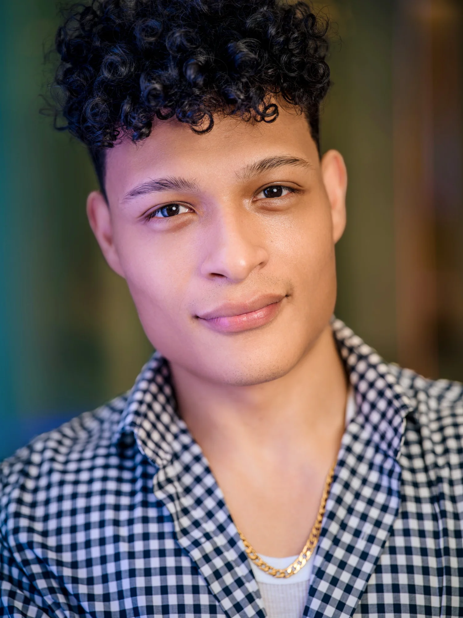 Flavio Gomez smiling in a gingham shirt