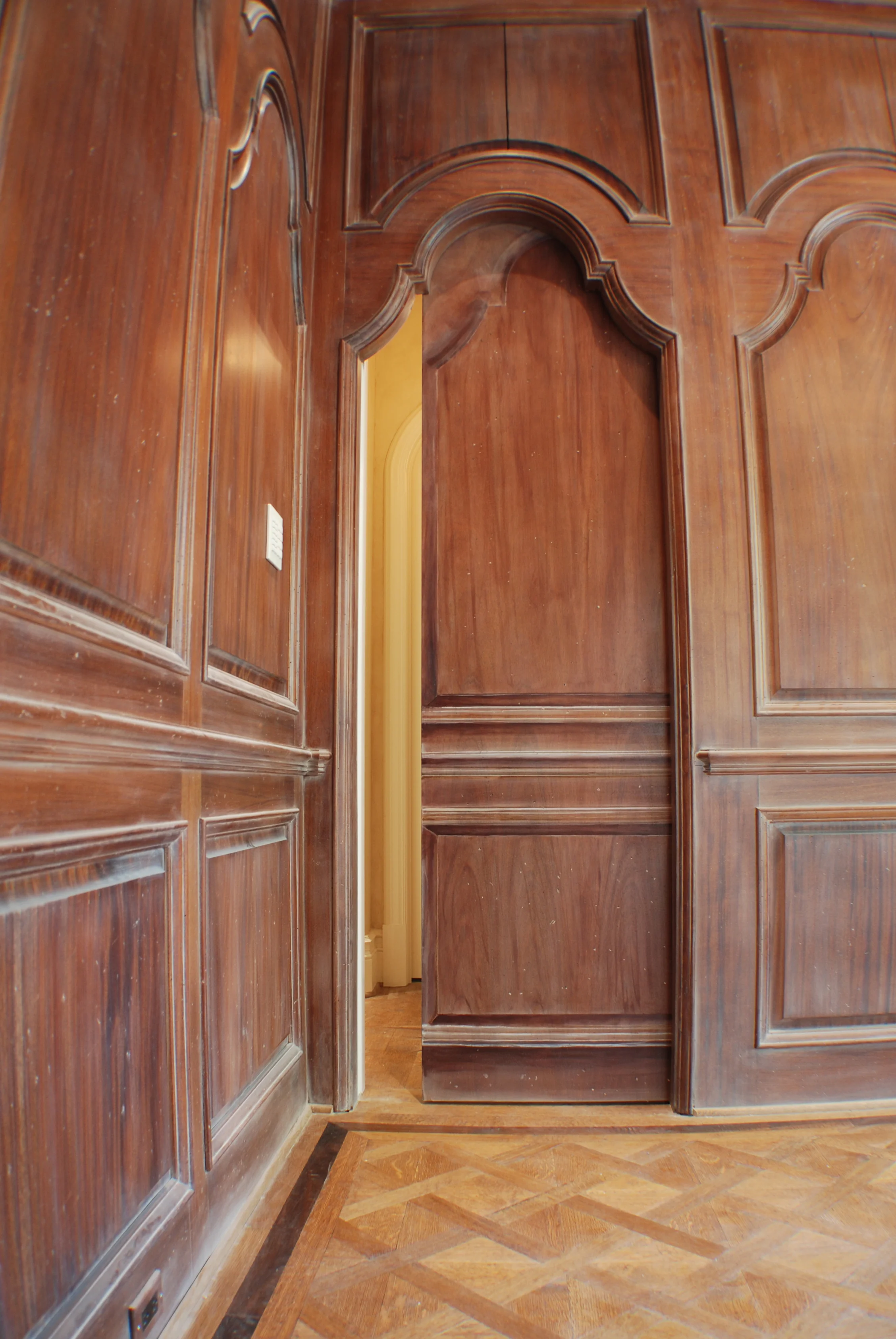  This flat pocket door is painted with trompe l'oeil molding to match the stained and glazed wood paneling.&nbsp; 
