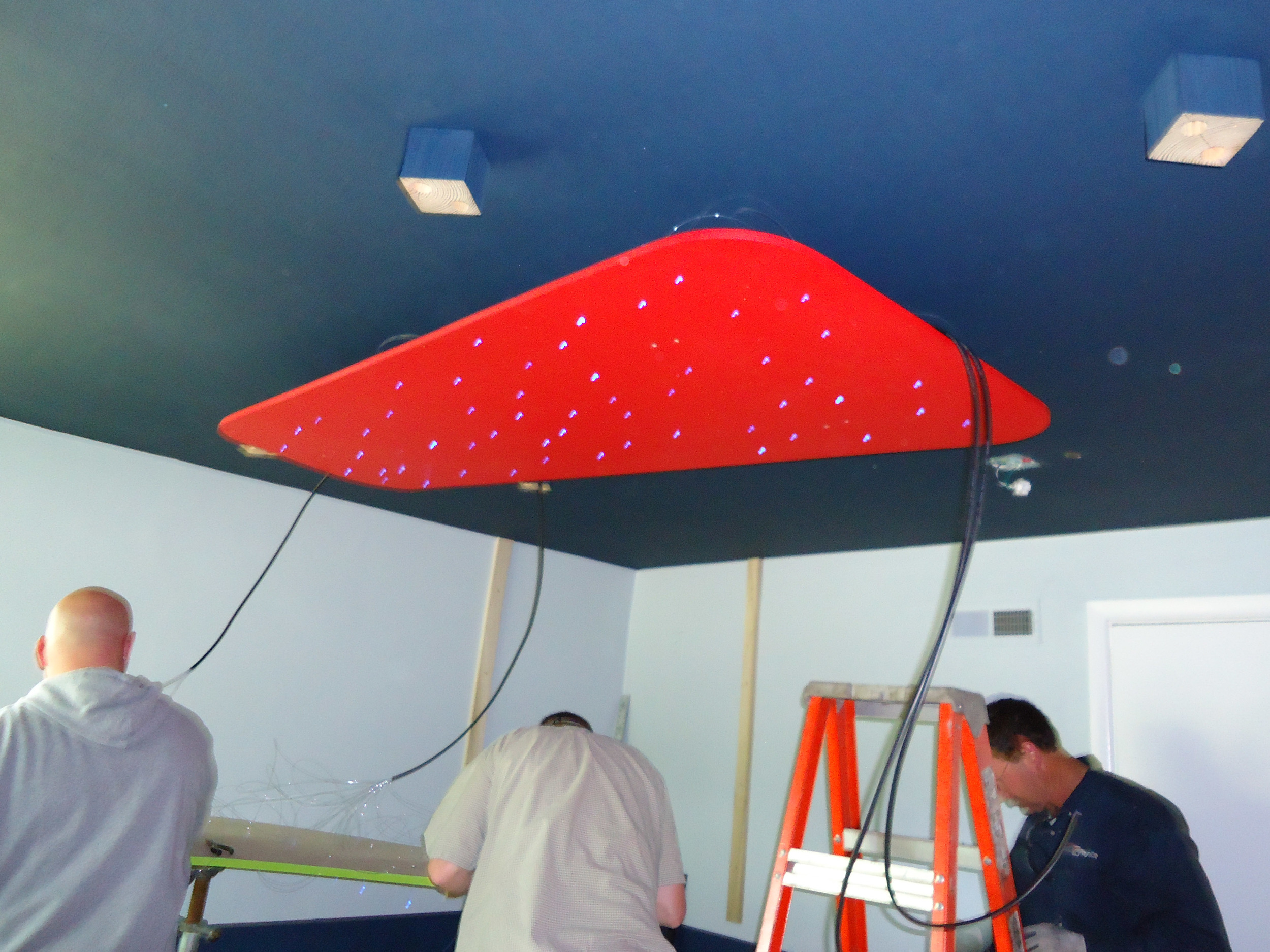Installation of red ceiling panel with LED lights