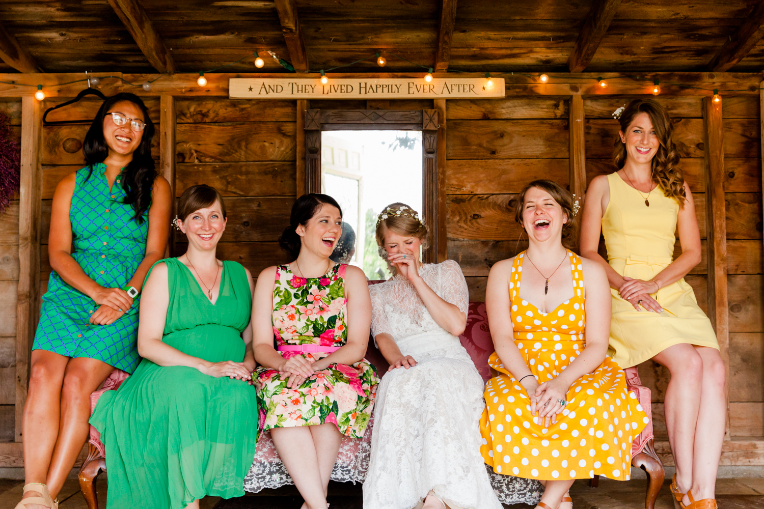  bridesmaids and bride sit on couch laughing in the Adirondacks 