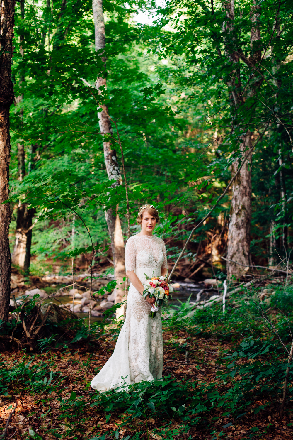  A bride stands in the Adirondack woods 