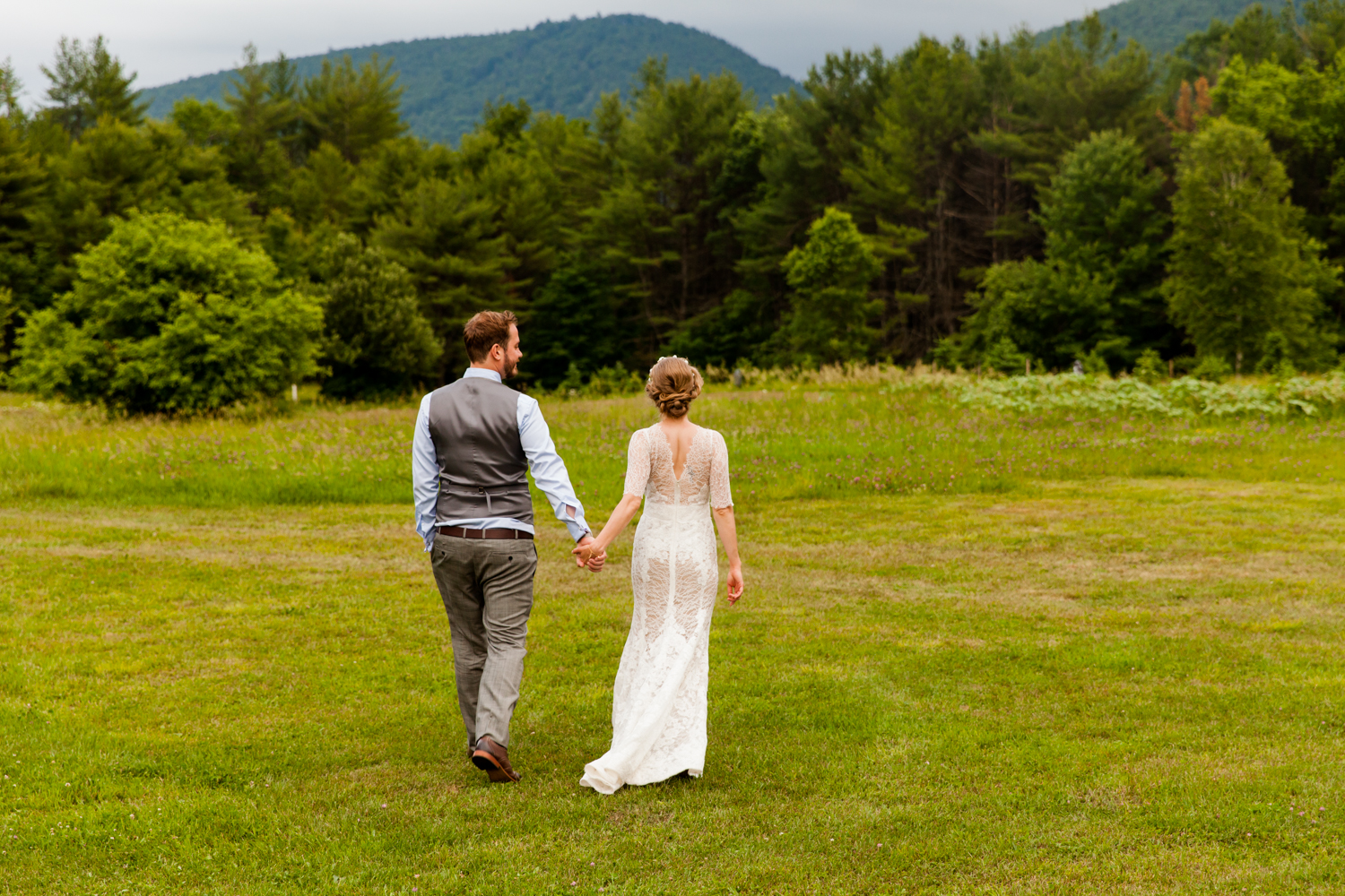  Bride and groom walk into a field 