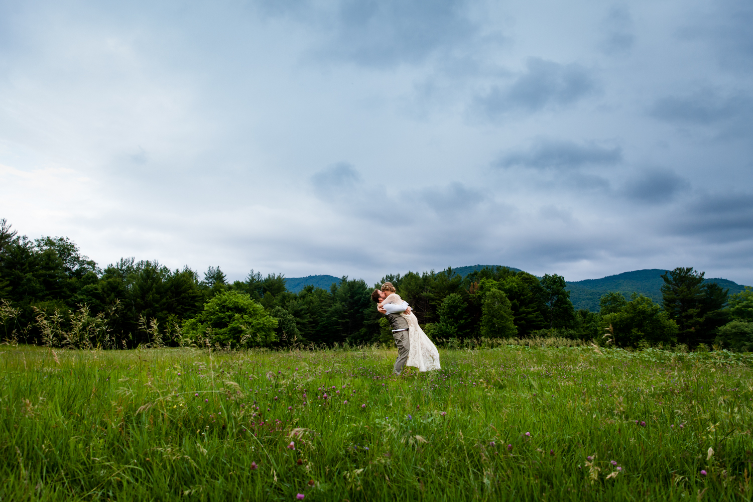  Groom lifts bride in a field in Upstate New York 