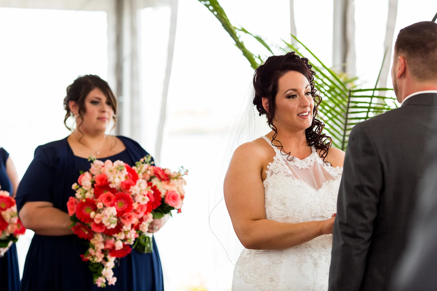 Bride looks at groom and says vows during wedding ceremony.