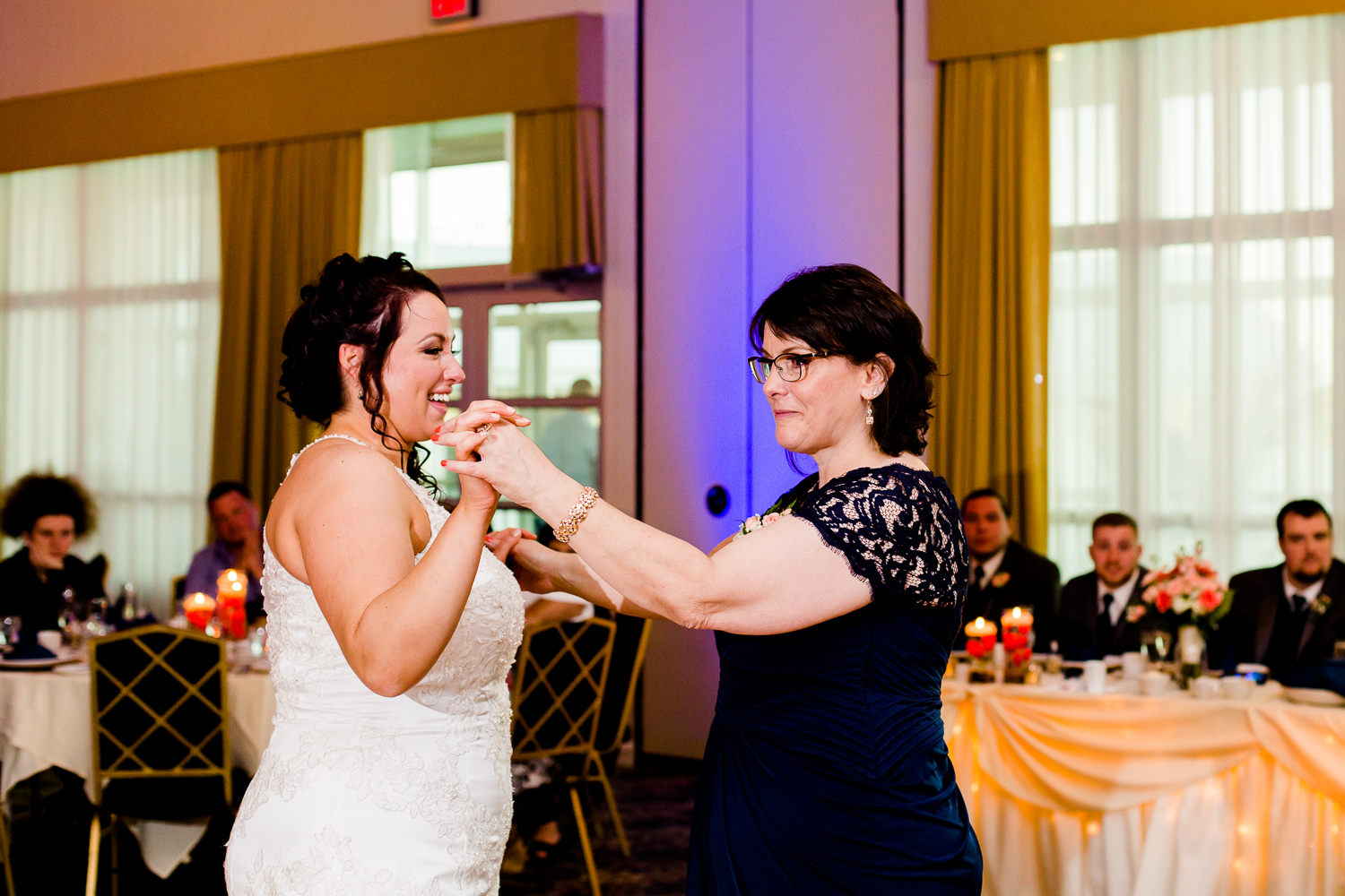 Bride laughs while dancing with her mother. 
