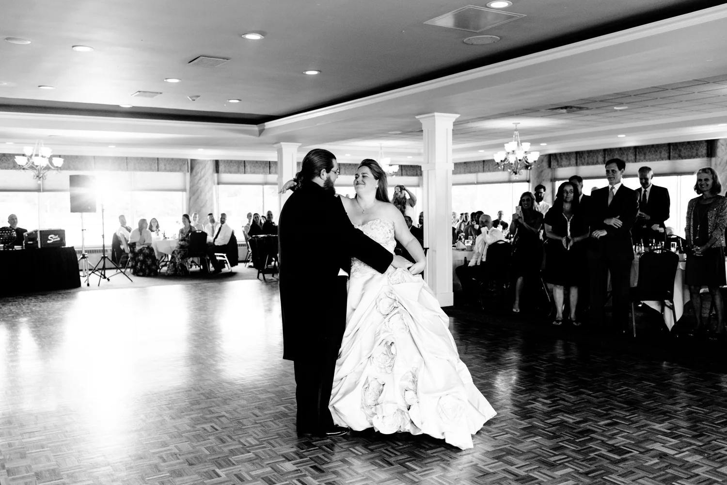 A black and white image of the bride and groom sharing their first dance.