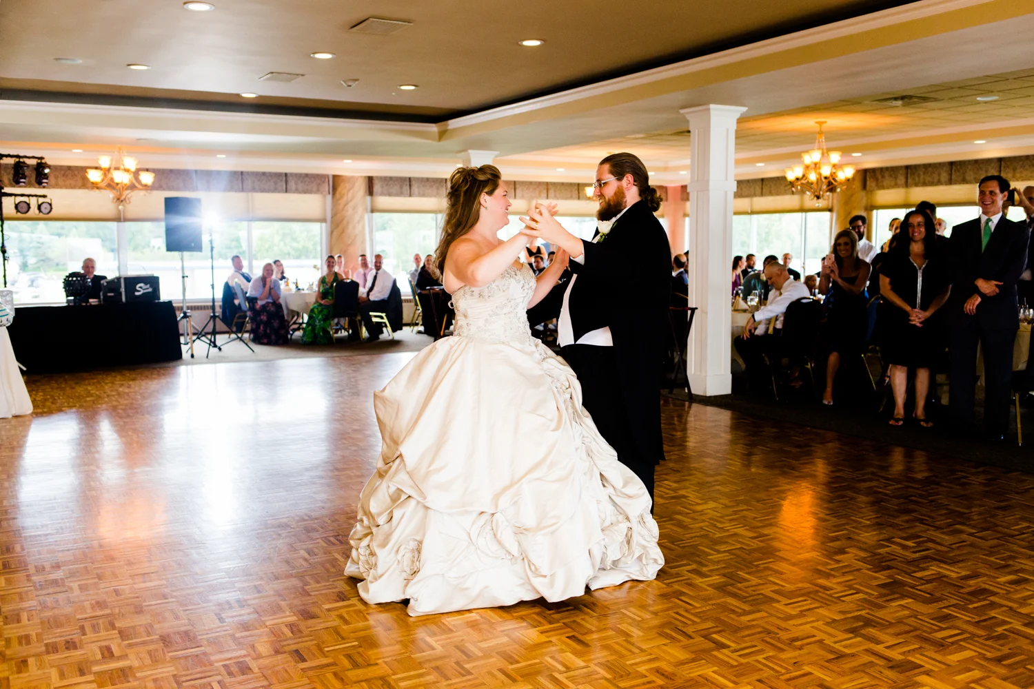 Bride and groom smile while sharing their first dance.