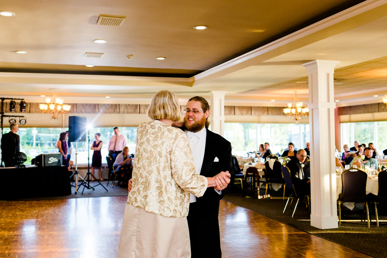 Groom smiles as he shares a dance with his mom.