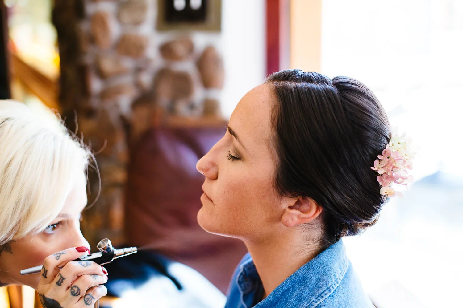 Bride getting airbrushed makeup.