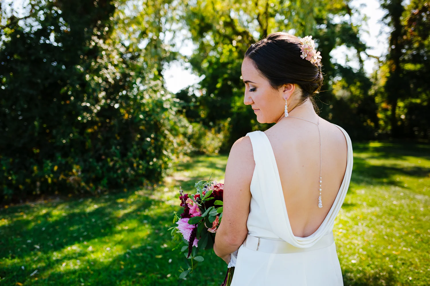Back of bride looking down at her bouquet.