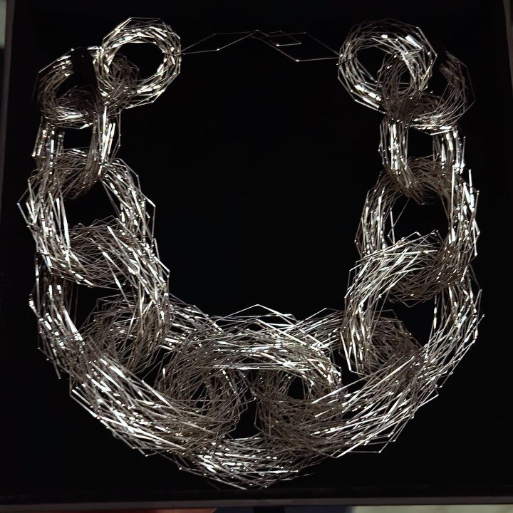 The Tenitic Tangle Neckpiece under two different light sources. The first video was taken in the evening with only artificial light. The second was taken in full daylight, lit by the sun. 
This wearable sculpture is made from formed, woven, welded an