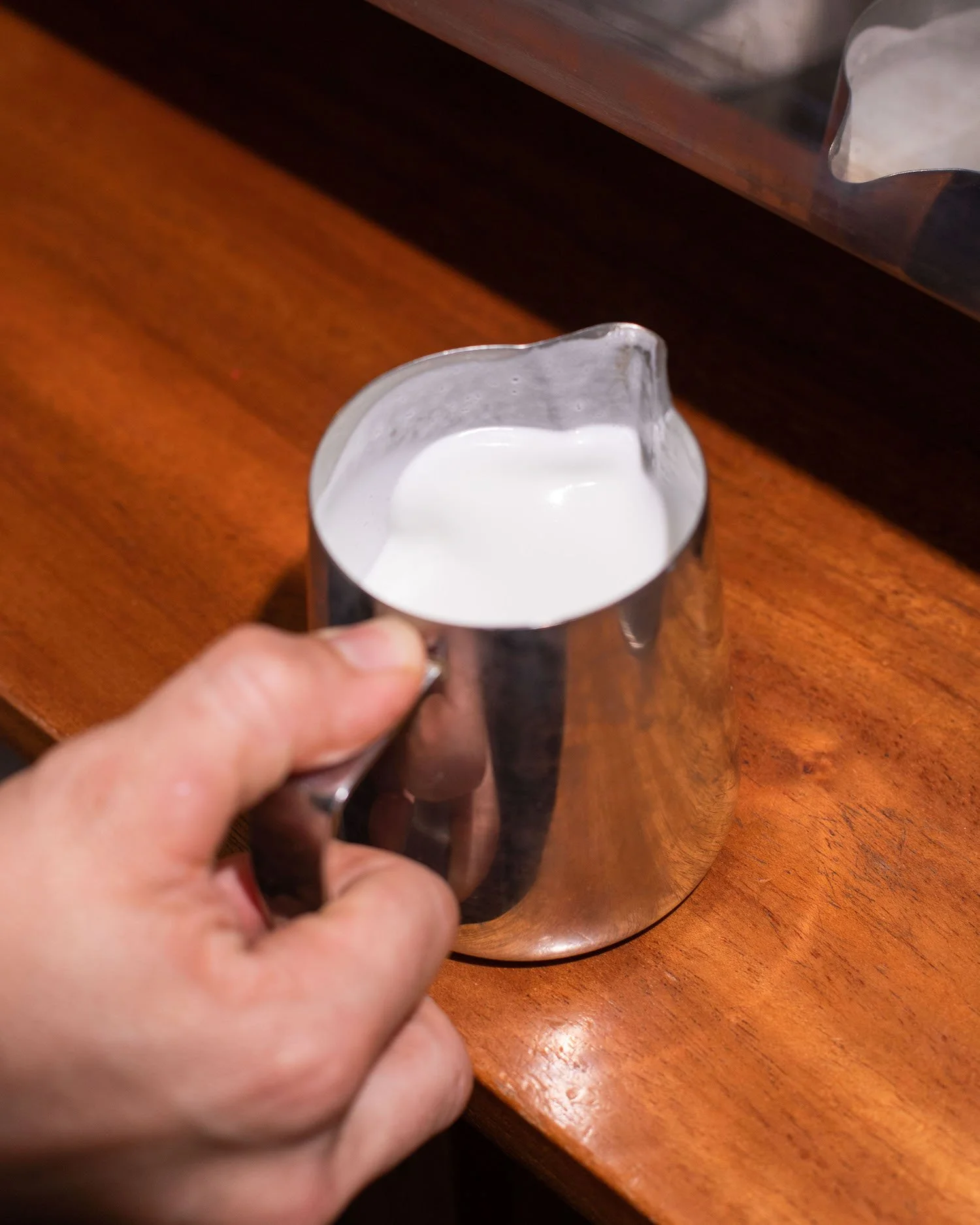steamed milk in pitcher for latte art