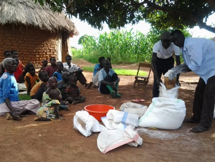 Hungry children and some church members watching Pr. Opure Alex distributing flour.jpg