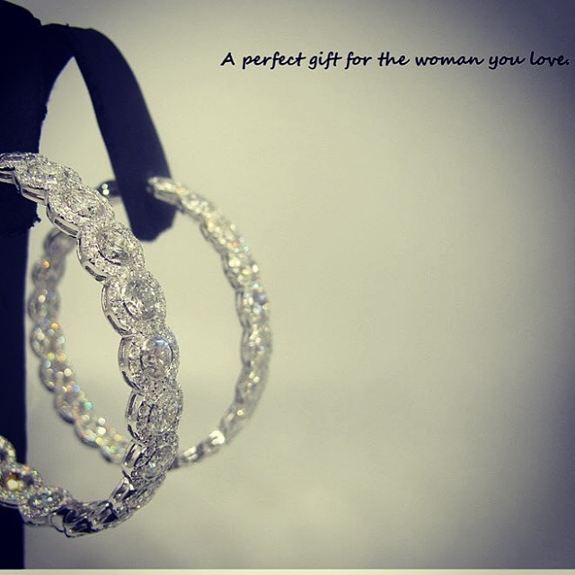 Diamond hoop encircled earrings with smaller halos of full cut round diamonds.