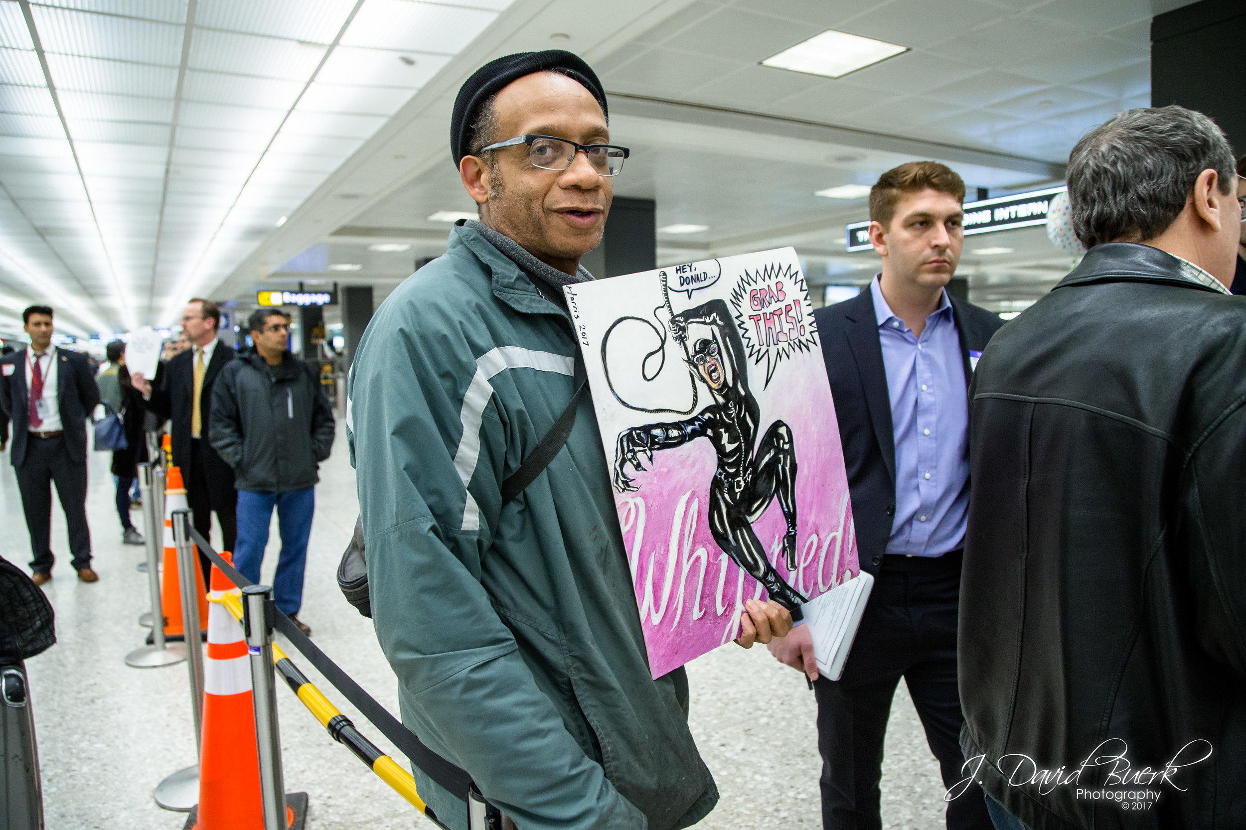 Many of the protestors present also took part in the Women's March on Washington on January 21st, 2017; the day after President Trump's inauguration. Some of these protestors brought their signs from that protest to use at this one; this sign is an original artwork.