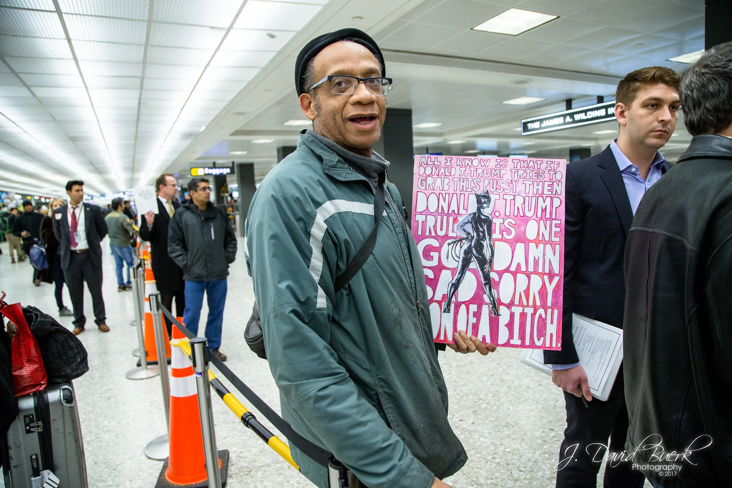 Many of the protestors present also took part in the Women's March on Washington on January 21st, 2017; the day after President Trump's inauguration. Some of these protestors brought their signs from that protest to use at this one; this sign is an original artwork.
