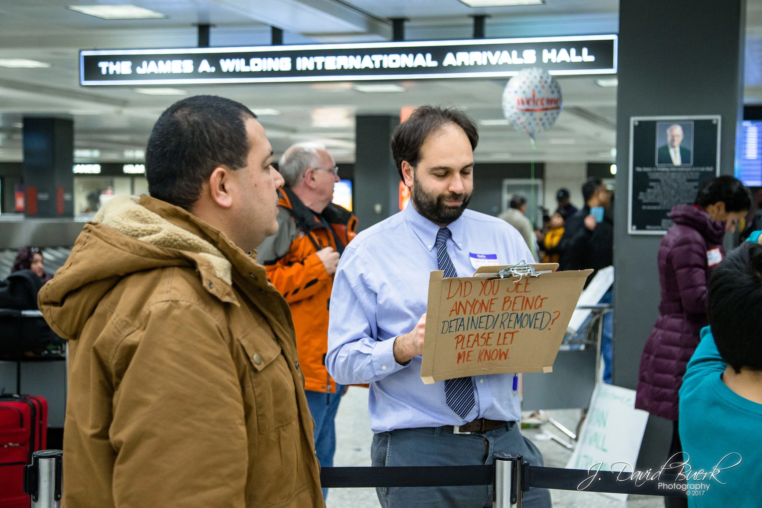 Volunteer lawyers and translators held signs to readily identify themselves to passengers and family who need legal counsel.