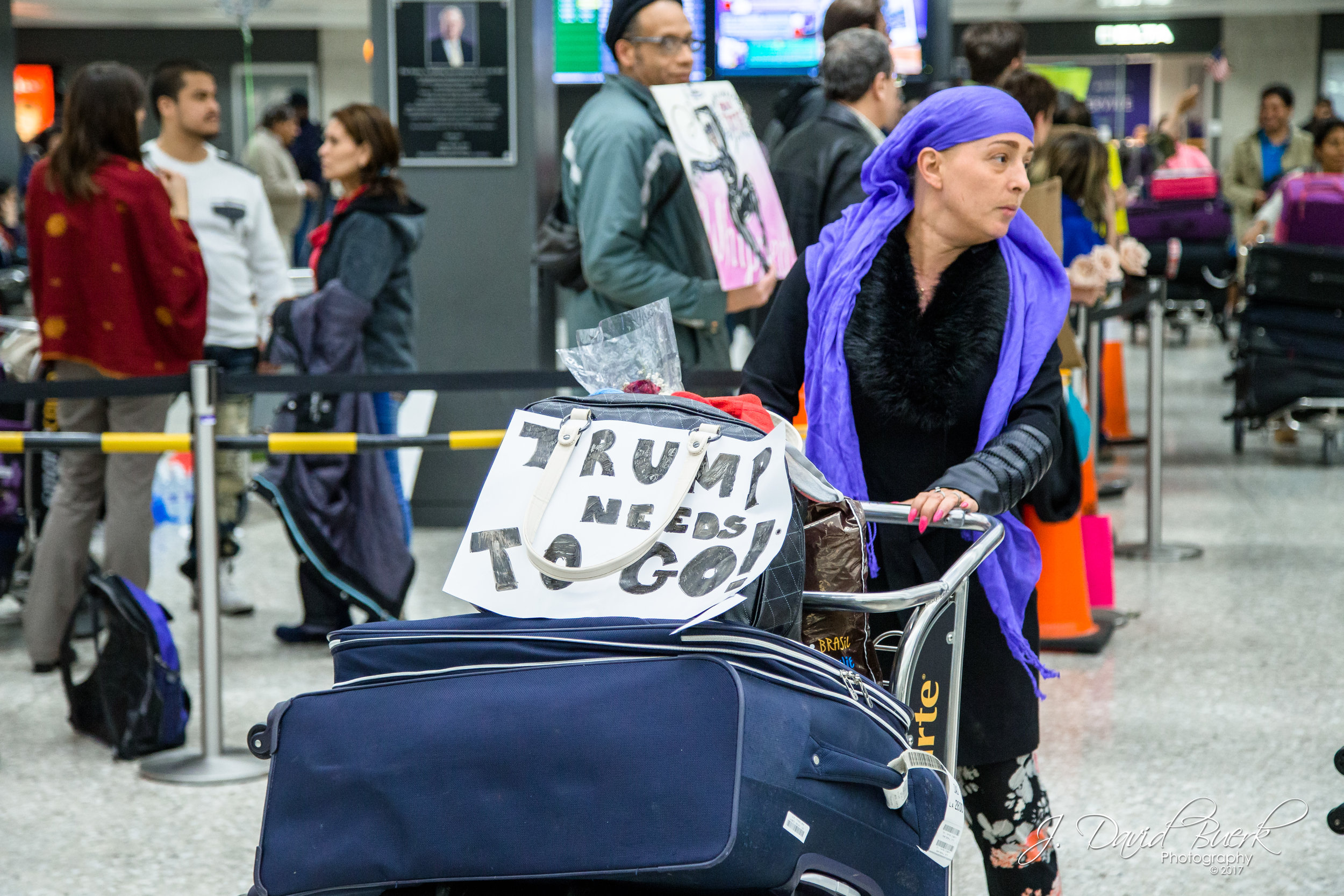 Even some arriving international travelers had signs in protest easily in view as they exited the International Arrivals Building upon clearing customs.