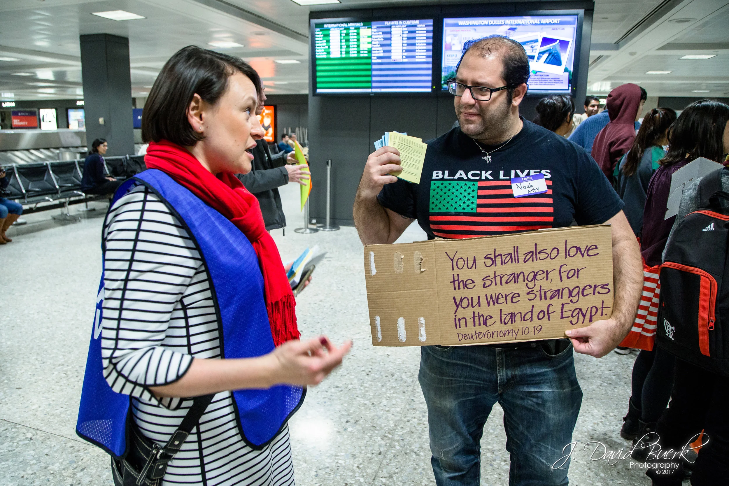 A Black Lives Matter protestor and attorney speaks with an ACLU legal observer while holding ACLU legal advice pamphlets.