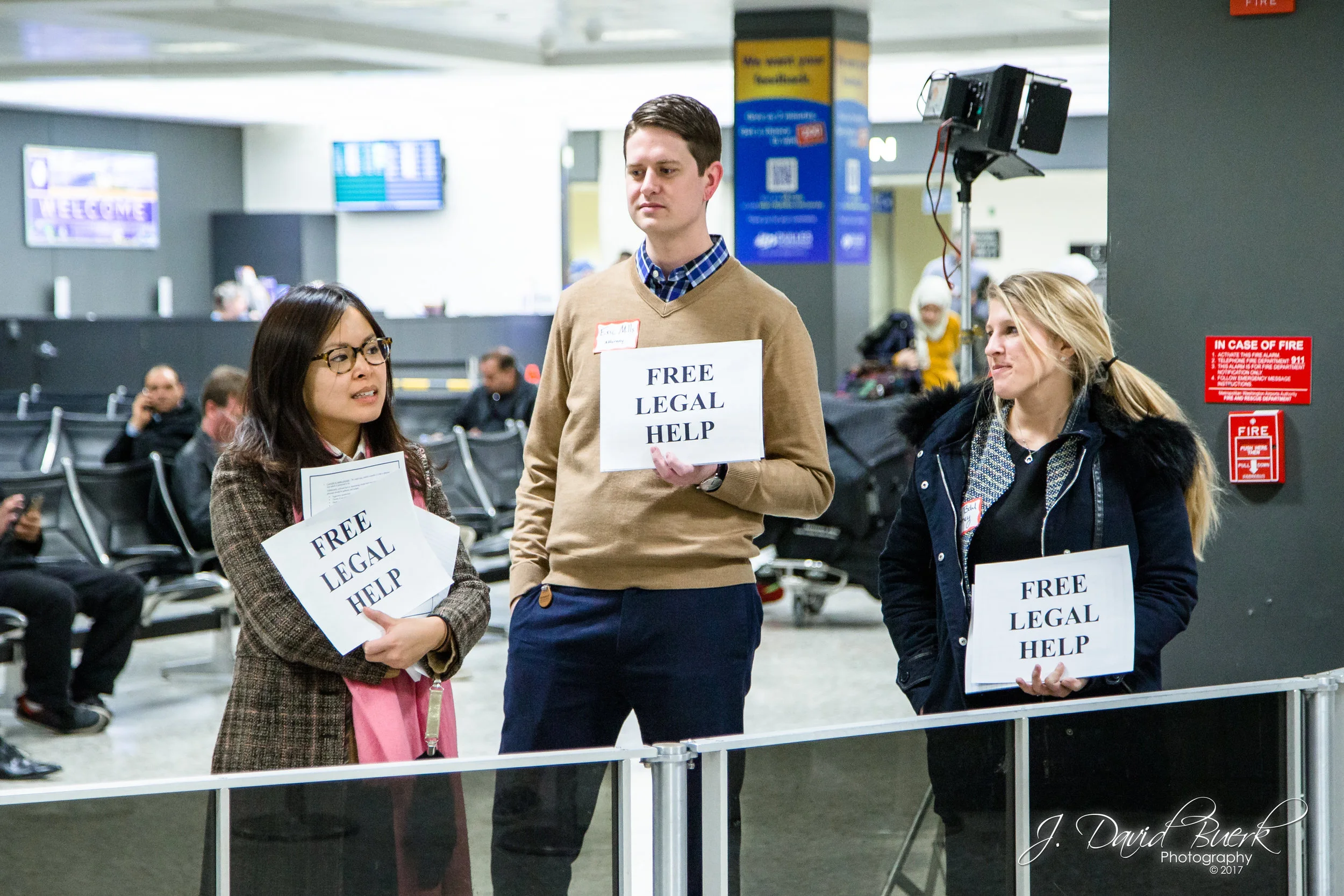 Volunteer lawyers stand close to the International Arrival Building's exit with clearly legible signs reading, "FREE LEGAL HELP." When news of the travel ban broke on Saturday, lawyers and translators converged upon airports to donate their time and efforts in investigating and protecting against civil liberty violations.